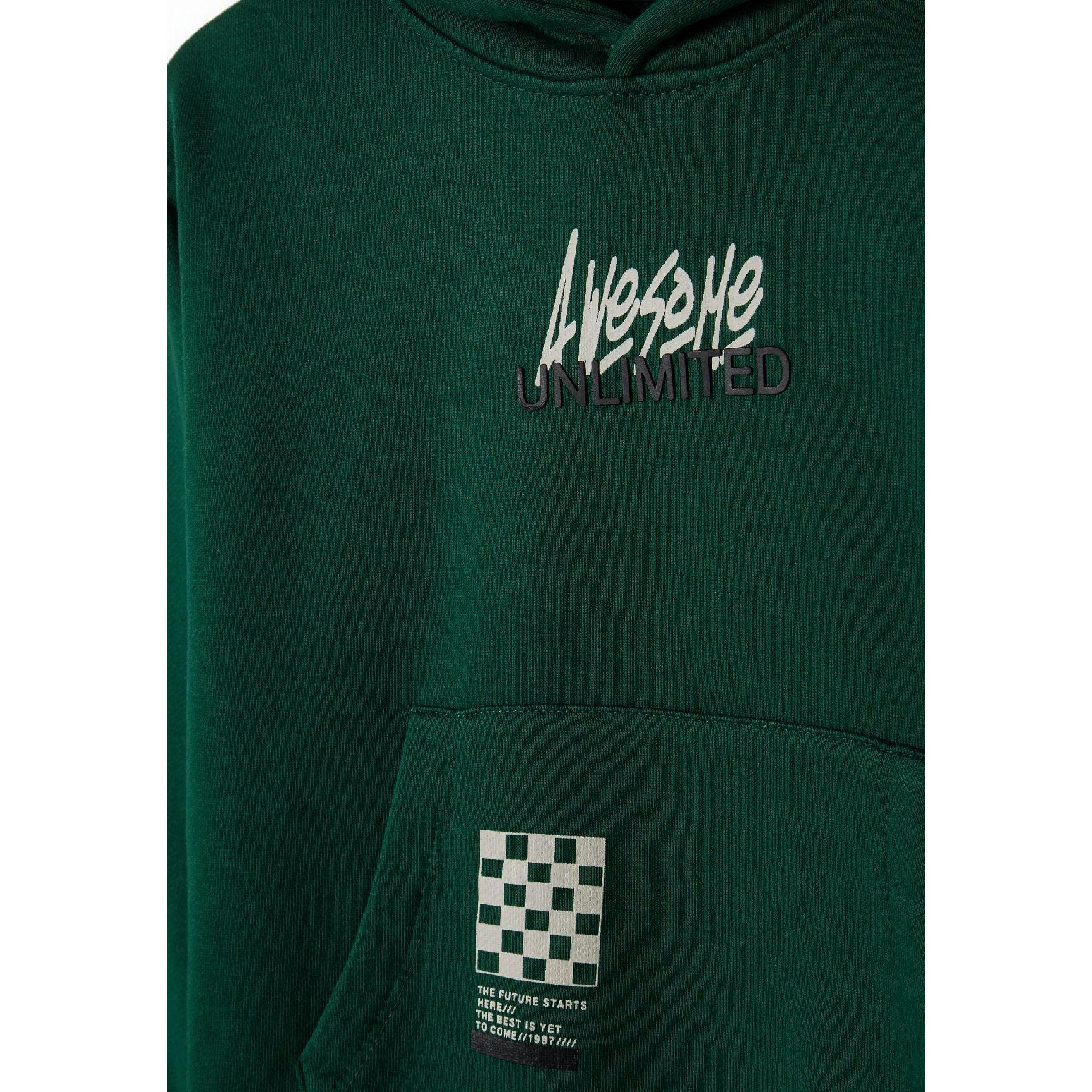 Close-up detail of Awesome Unlimited print in white and black text on green fleece fabric