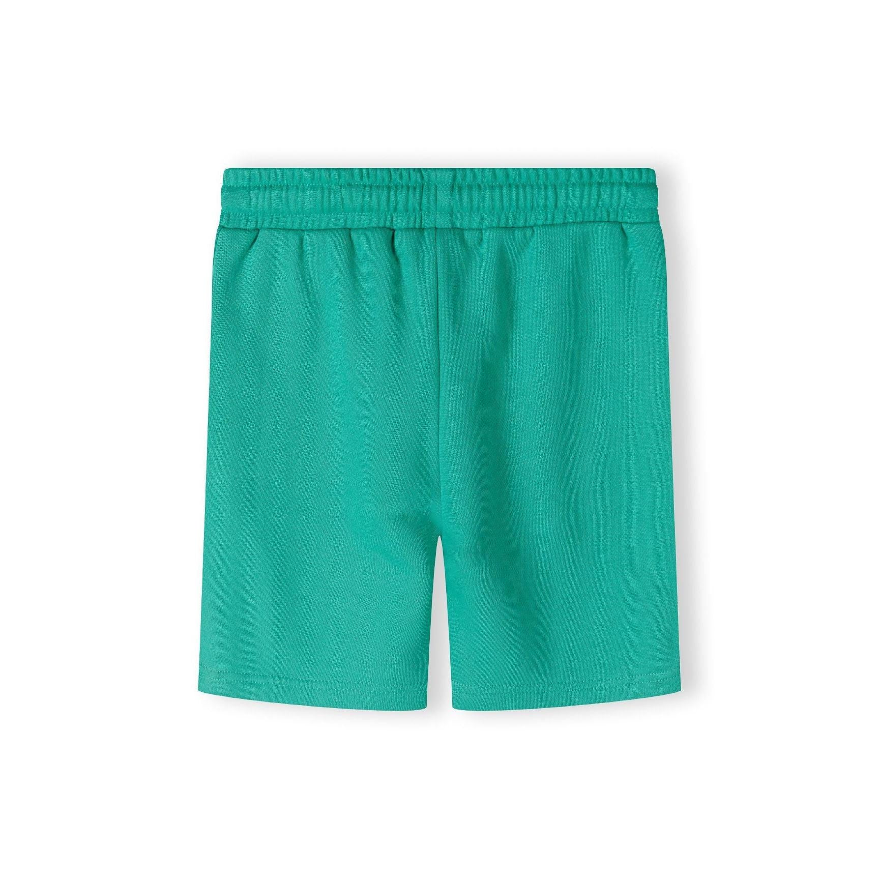 Bright green fleece shorts laid flat showing elasticated waistband and relaxed fit on white background