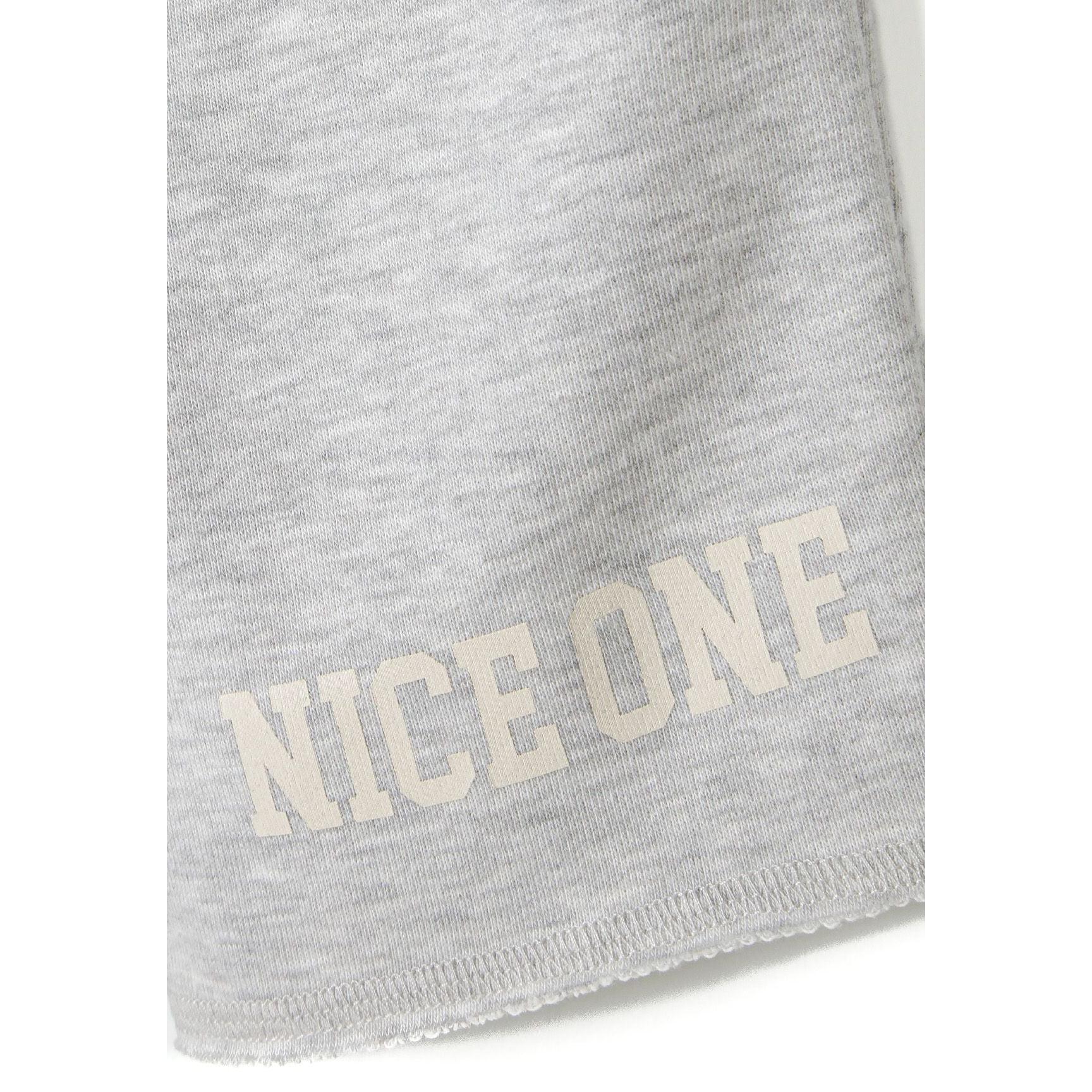 Close-up detail of grey shorts showing Nice One text print on leg and hemmed bottom edge on white background