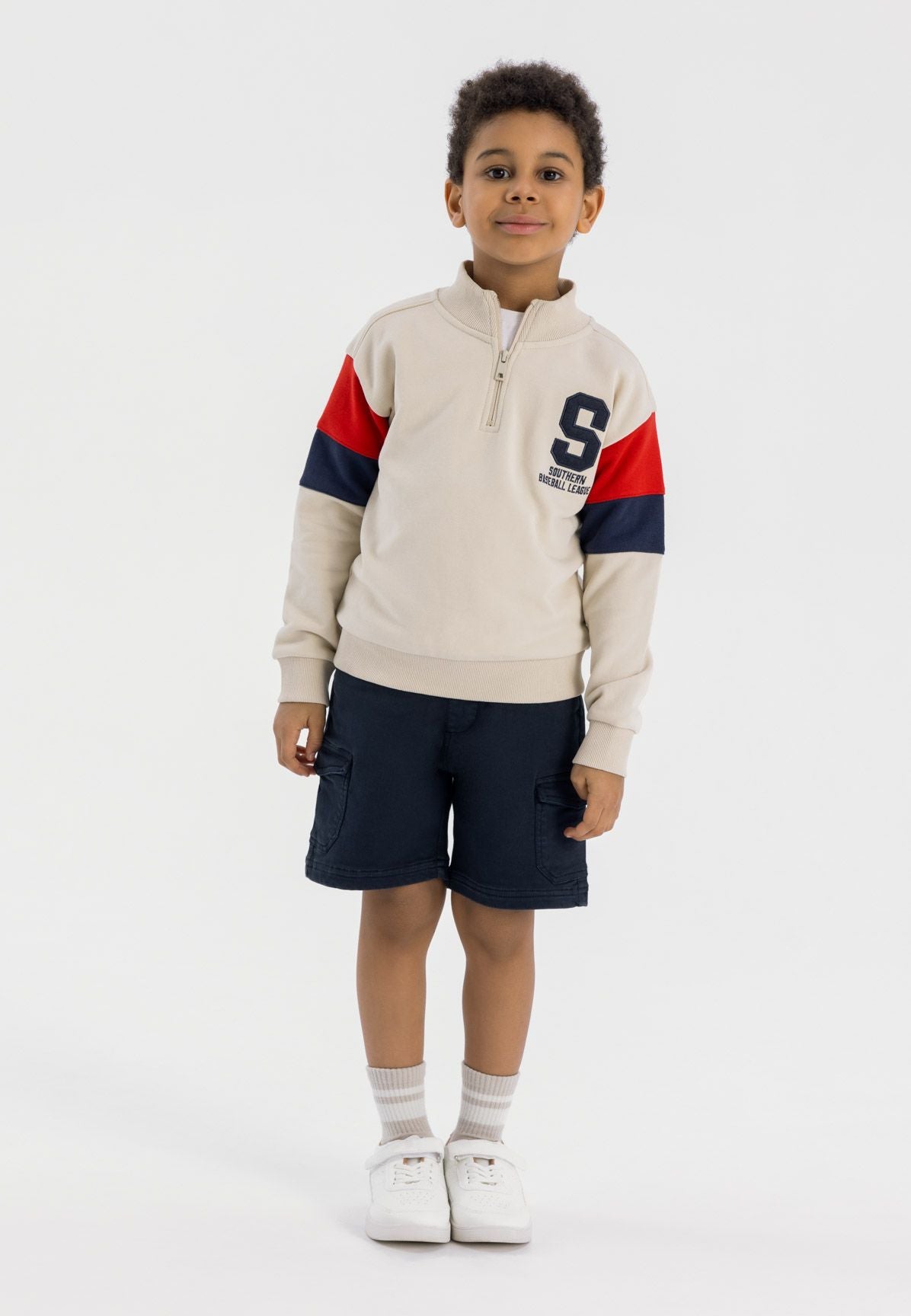 Boys half zip jumper in cream with rib cuffs, featuring contrasting red and navy sleeves.