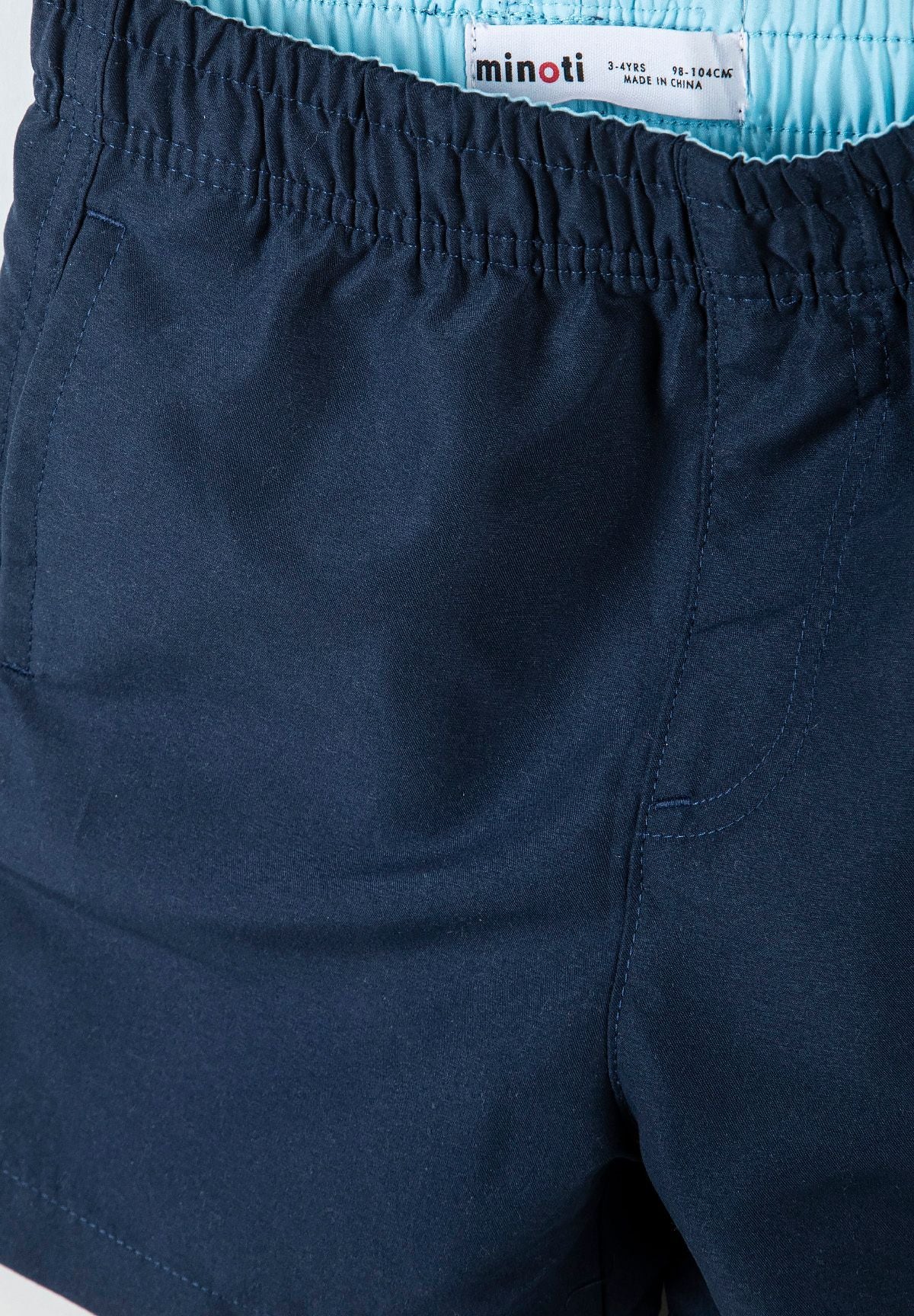 Detail of boys navy swim shorts with elasticated waistband.