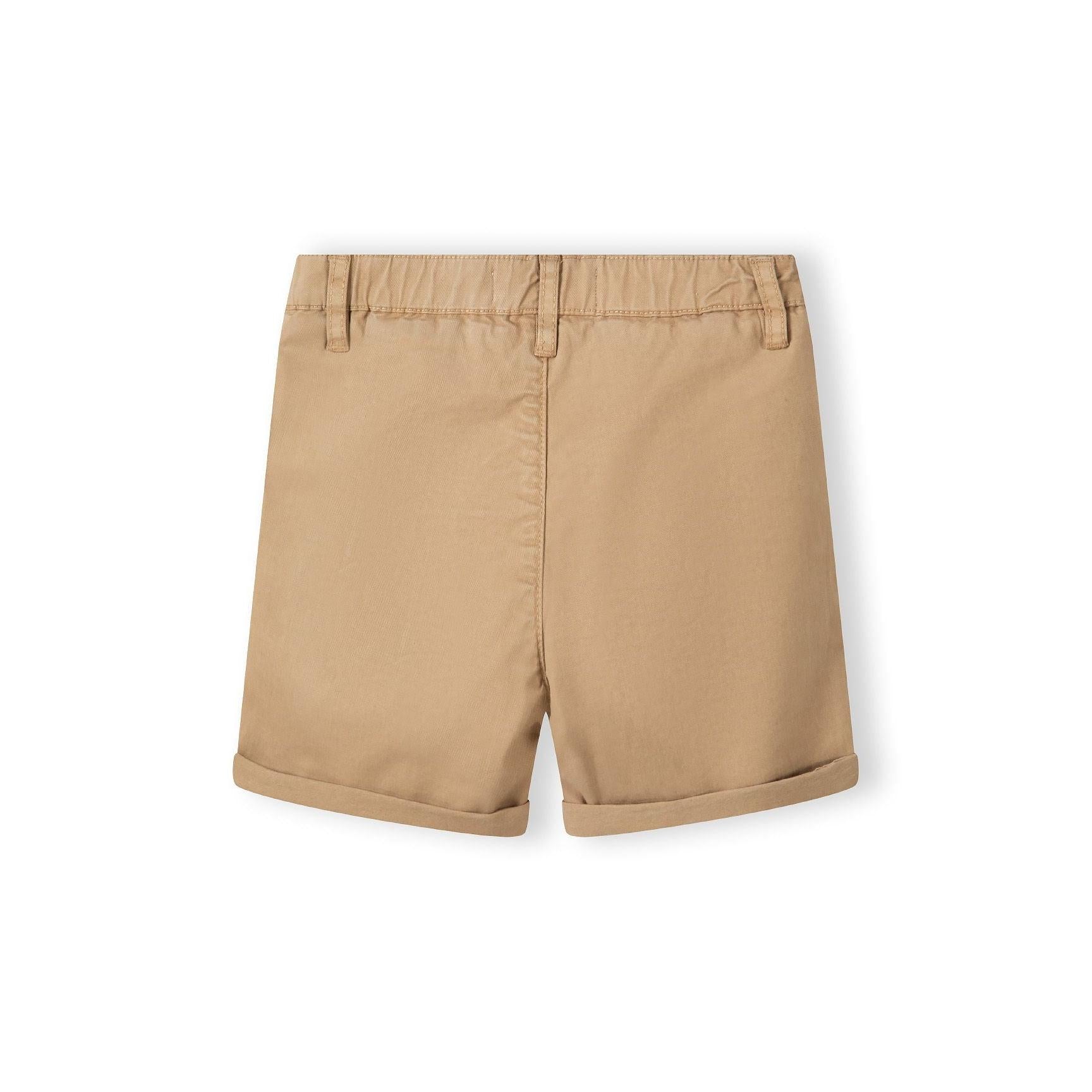 Close-up detail of stone beige chino shorts showing Minoti label, button closure and pocket construction
