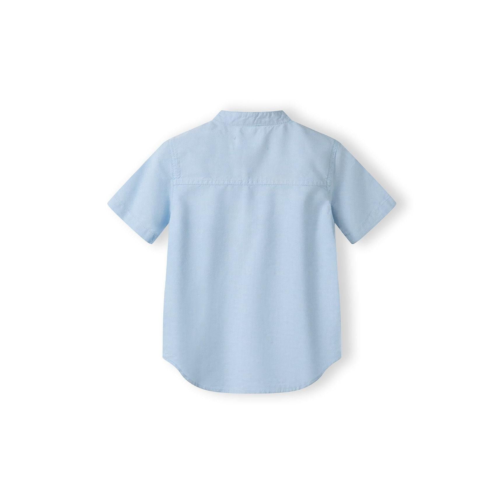 Back view of light blue grandad collar shirt showing collar detail and curved hem against white background