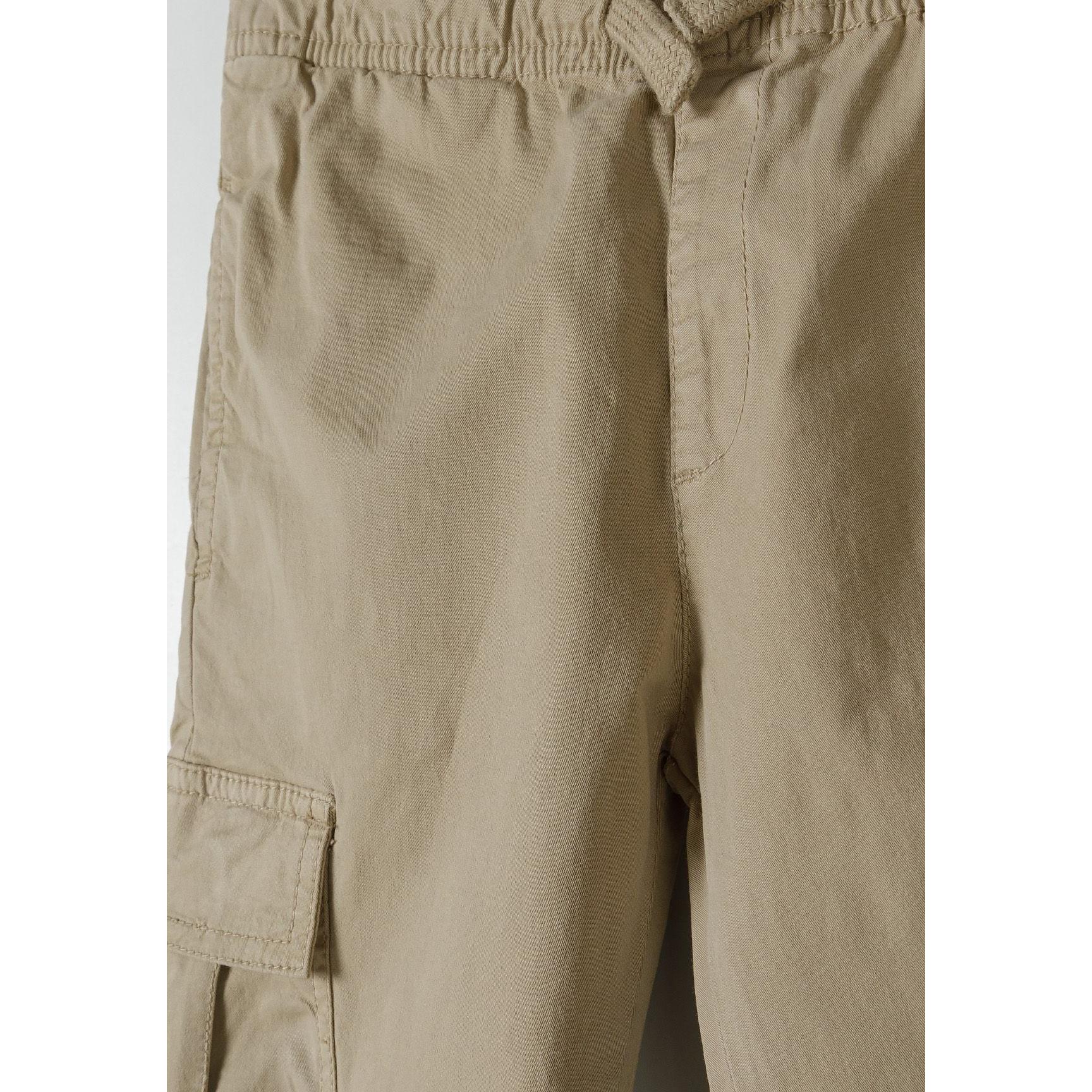 Close-up detail of khaki cargo trousers showing side cargo pocket construction and fabric texture