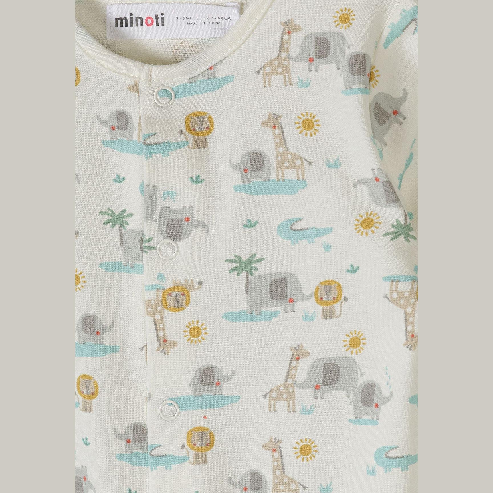 Close-up detail of cream safari print sleepsuit showing colorful animal motifs including elephants, giraffes, lions, crocodiles and palm trees with snap button closure
