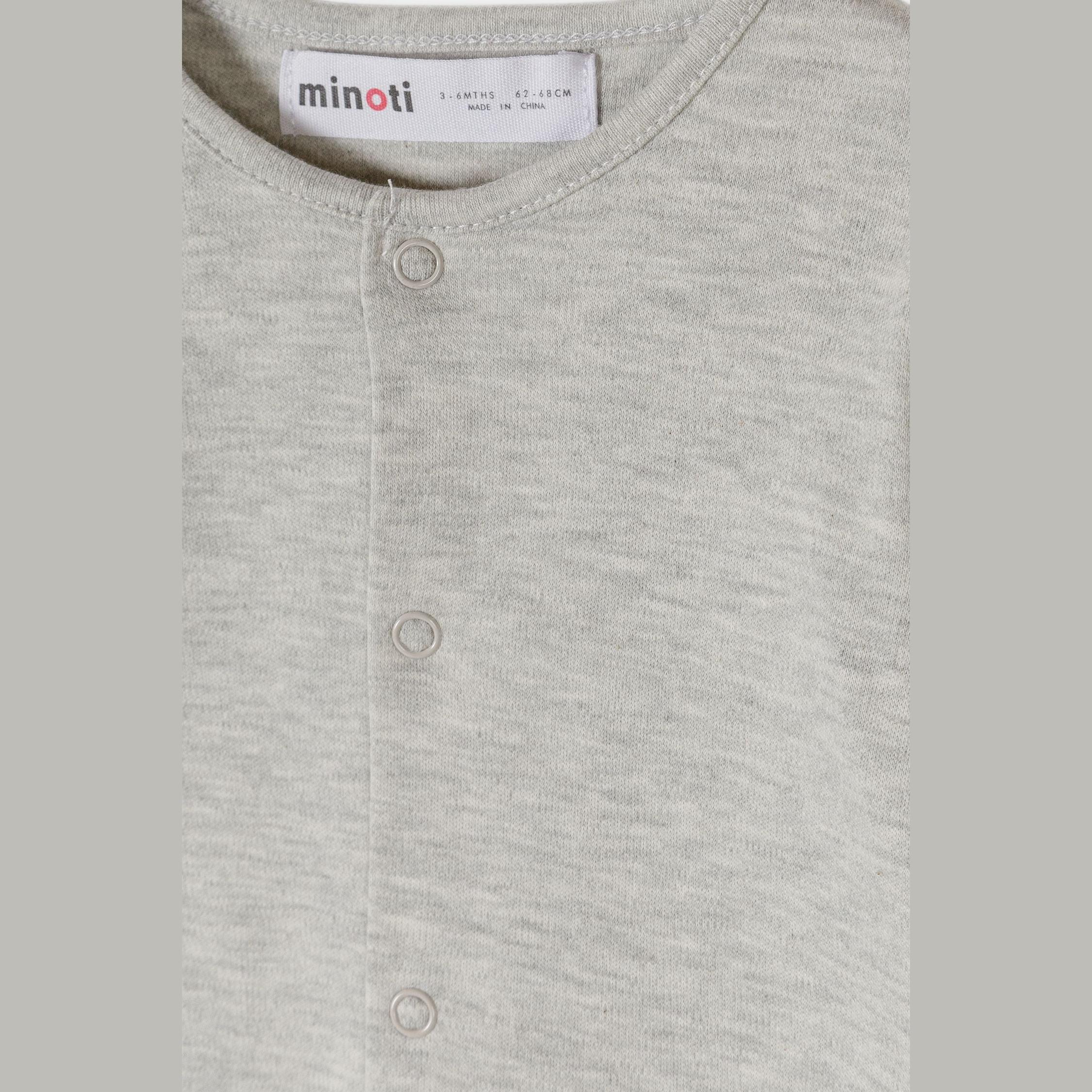 Close-up detail of grey marl sleepsuit showing Minoti size label and front popper buttons with soft cotton jersey texture