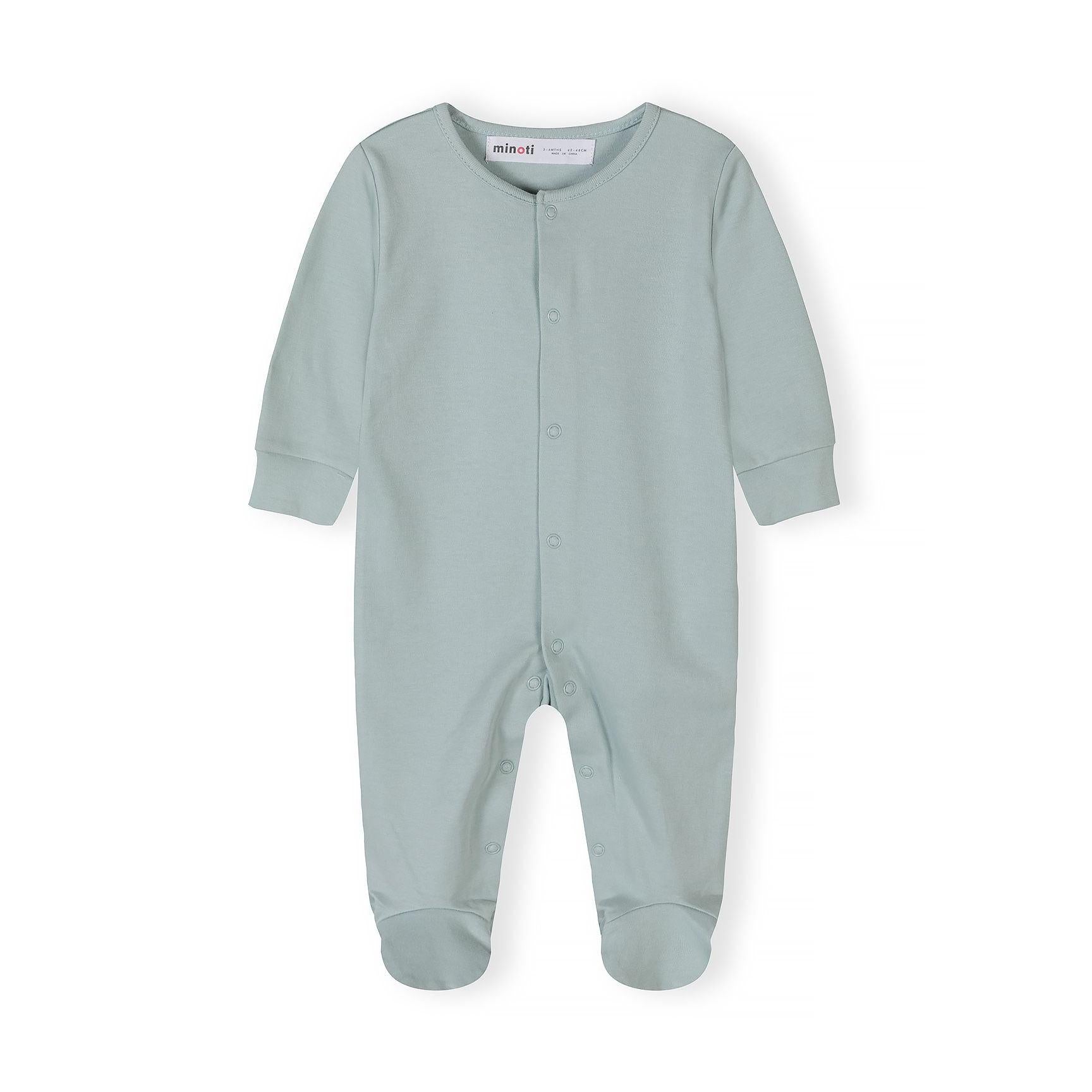Close-up detail of cream sleepsuit showing Minoti label, snap button closure and soft cotton texture with ribbed neckline