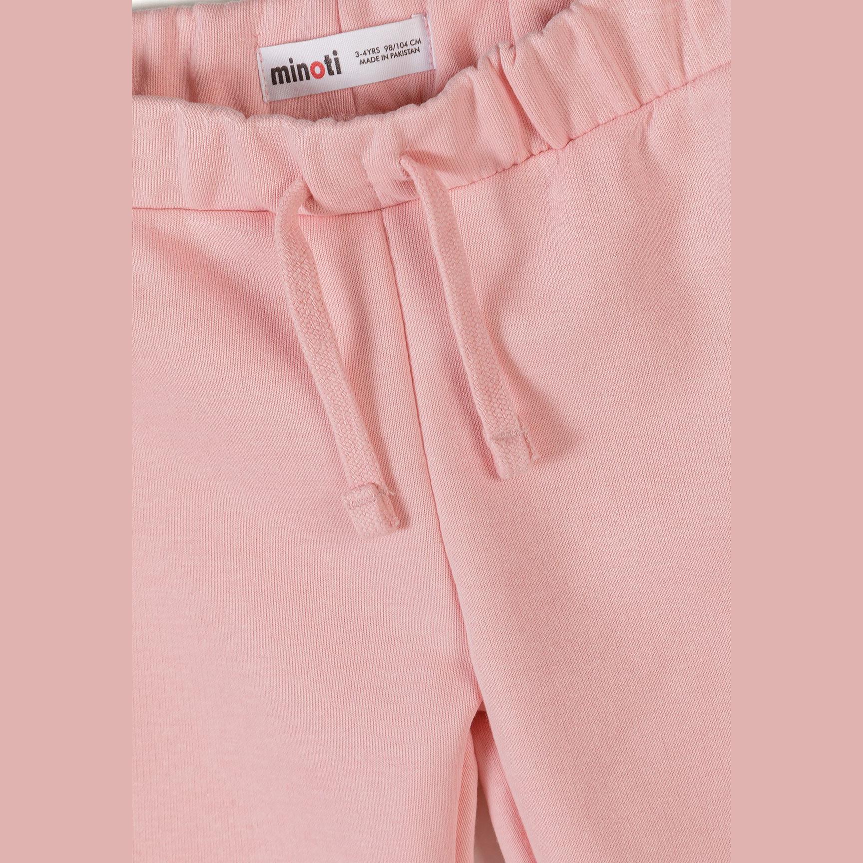 Close-up detail of pink joggers showing Minoti label and drawstring waistband with soft fabric texture