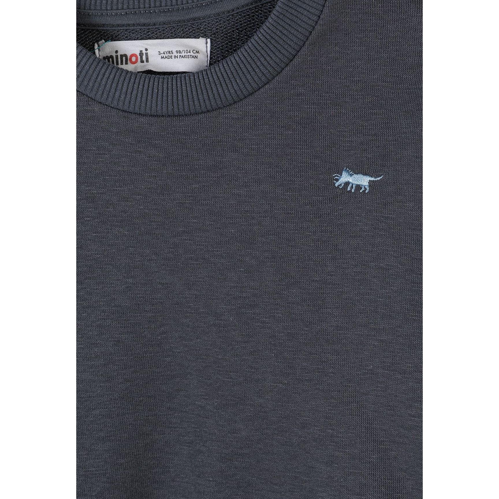 Close-up detail of gunmetal sweatshirt showing Minoti label and small embroidered animal logo on chest
