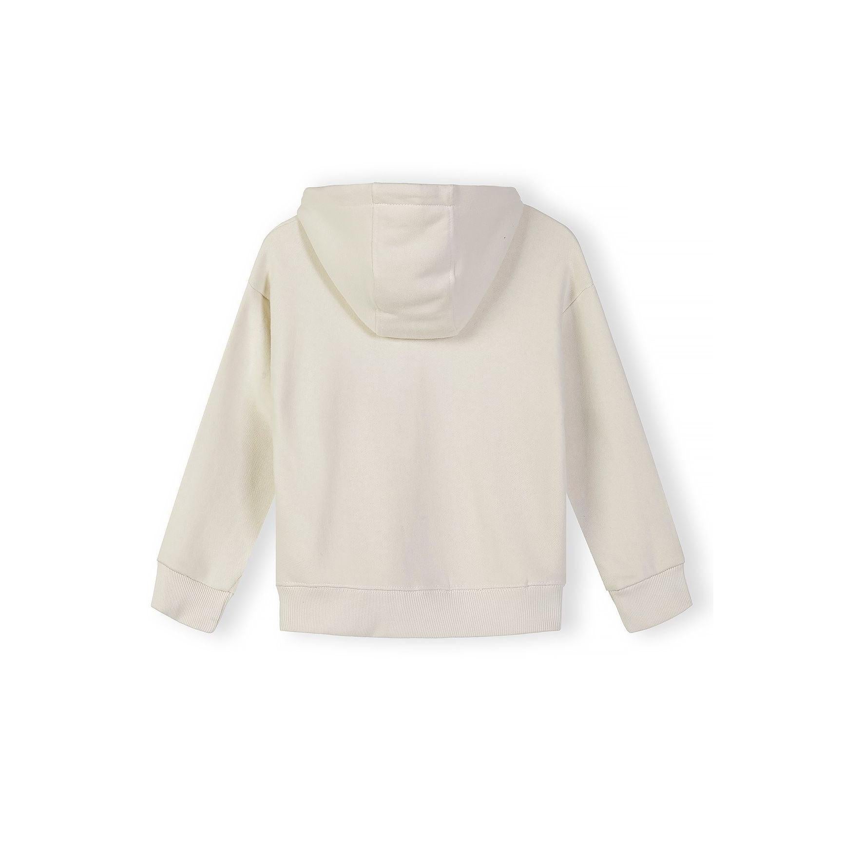 Close-up detail of cream hoodie showing zip closure, small text print on chest area, kangaroo pocket opening and soft cotton fabric texture