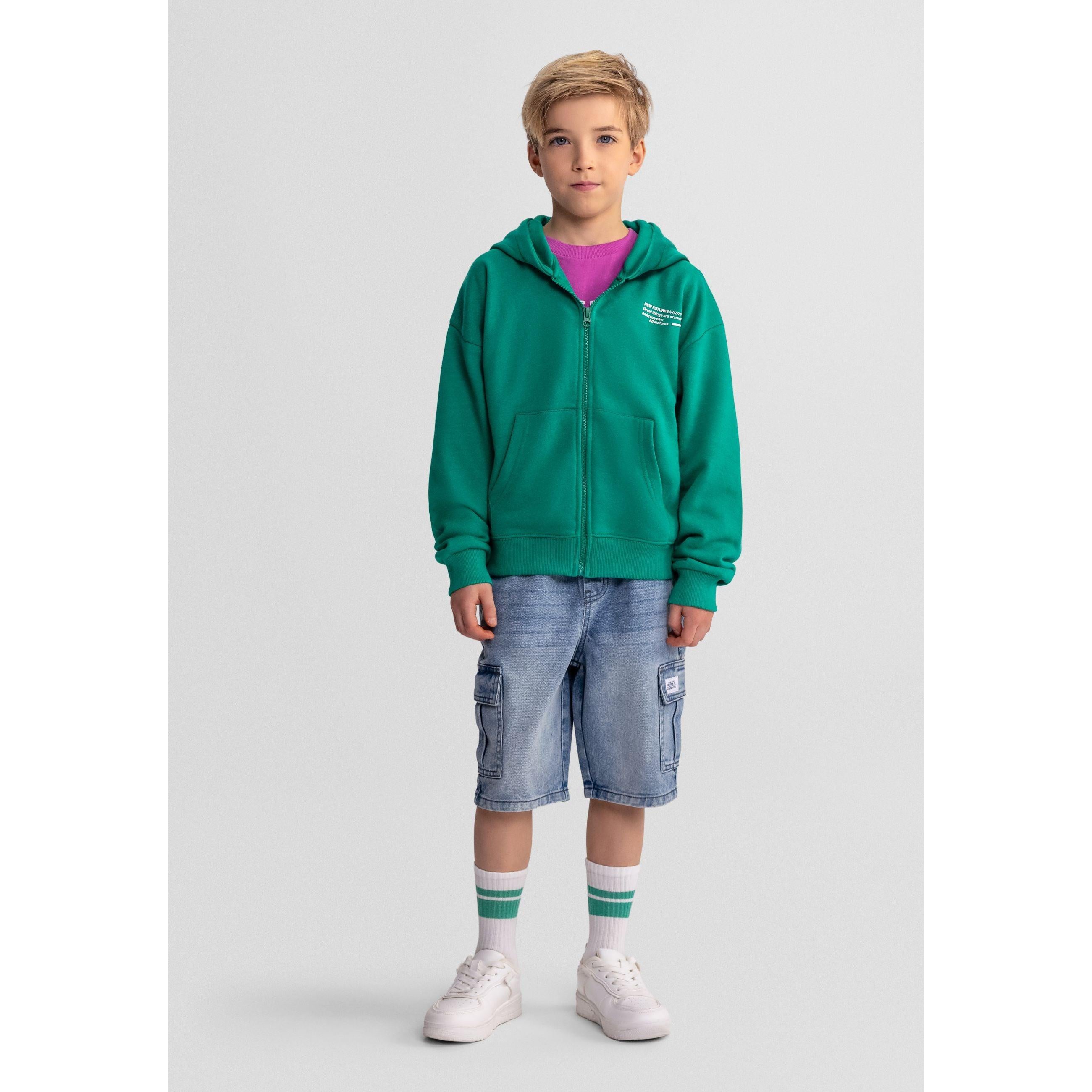 Close-up detail of green hoodie showing zip, Minoti label and text print on chest