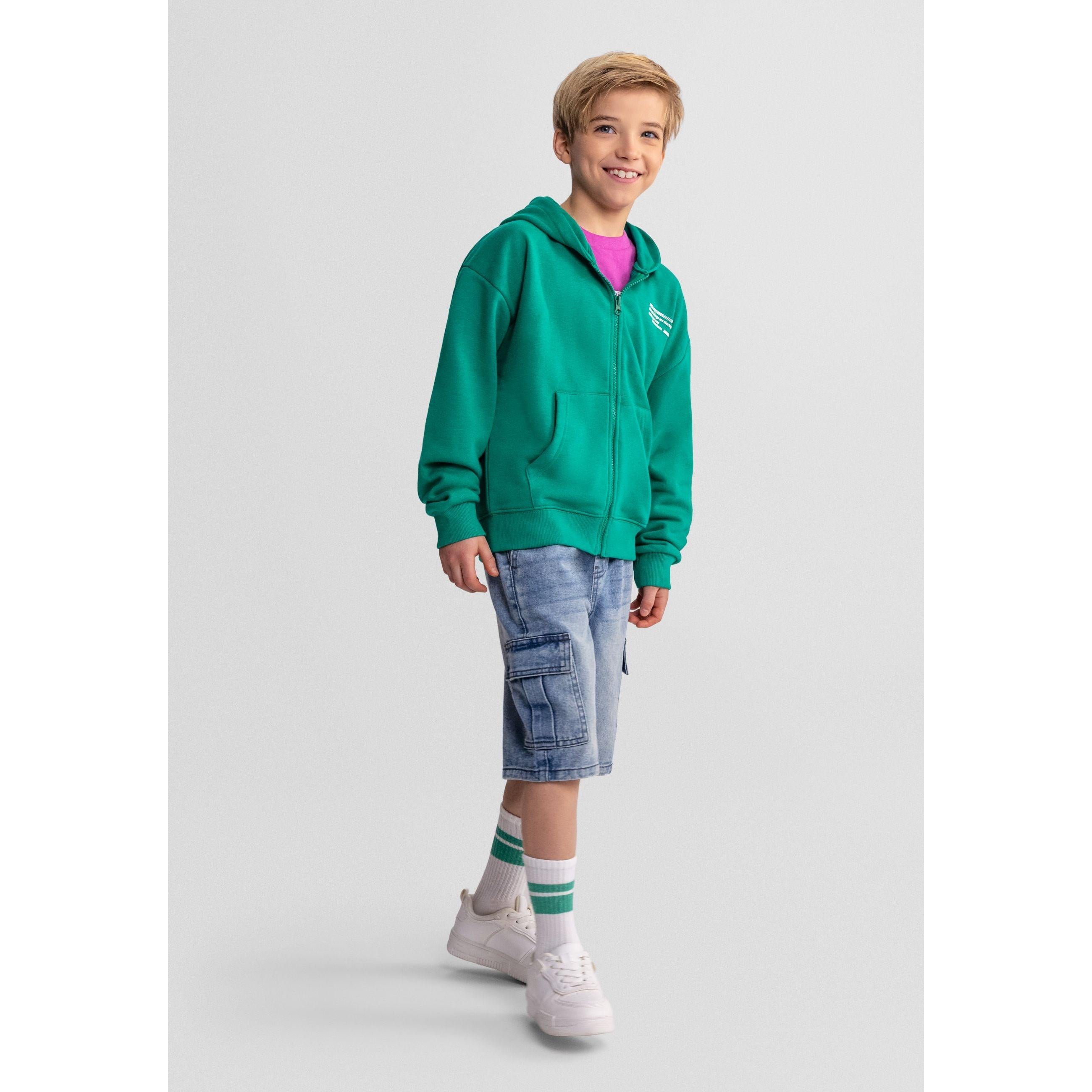 Close-up detail of green hoodie showing zip, Minoti label and text print on chest