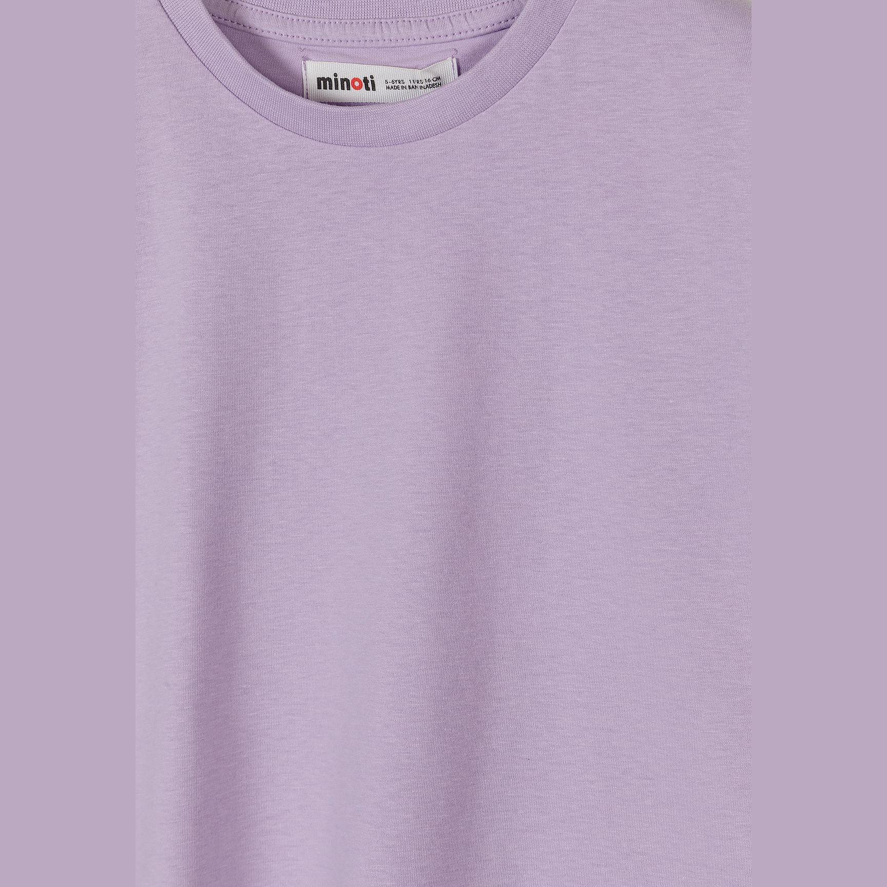 Close-up detail of lilac t-shirt showing Minoti brand label at neck and soft cotton fabric texture on white background