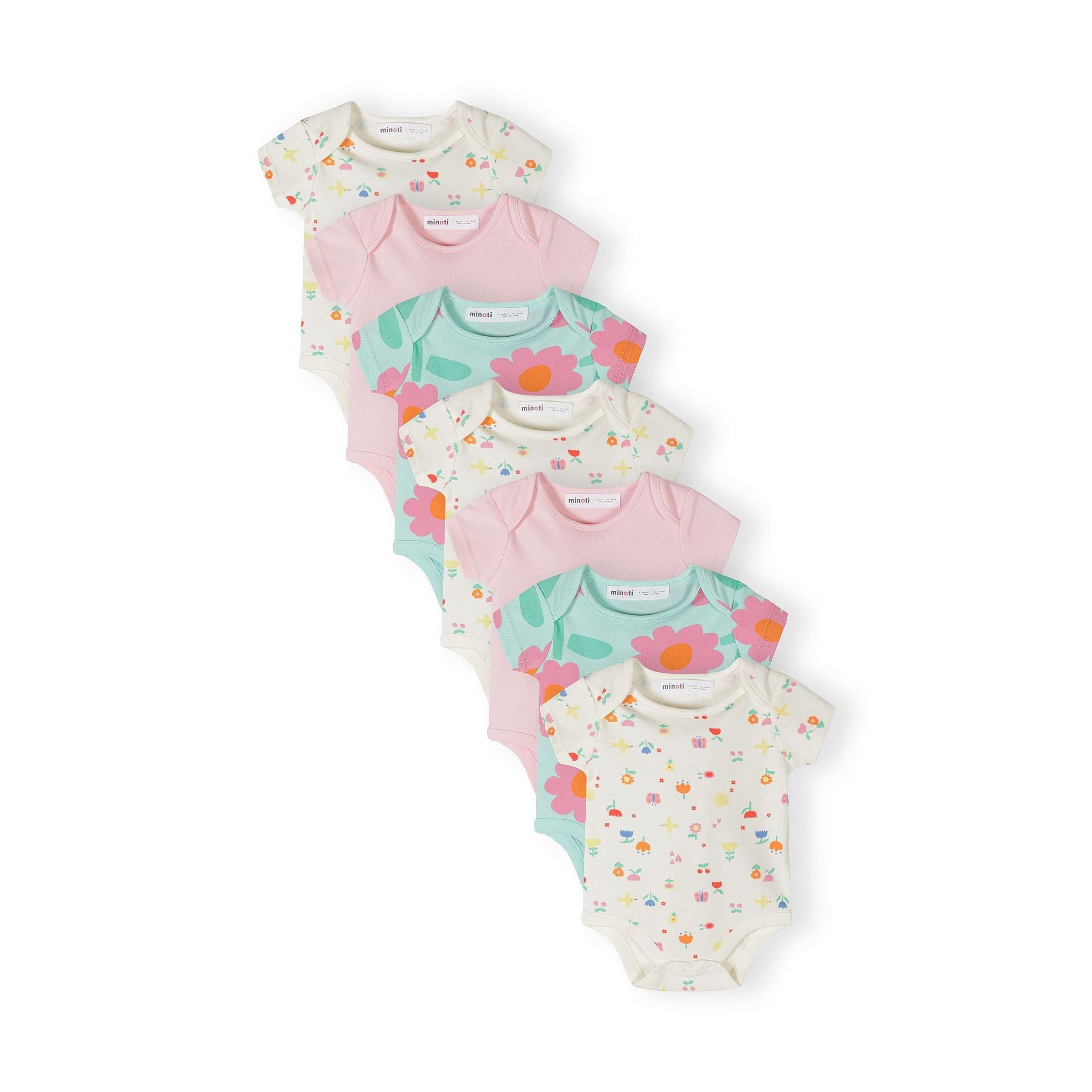 Seven baby bodysuits arranged in overlapping display showing mint floral prints, pink solids and cream with small motifs on white background