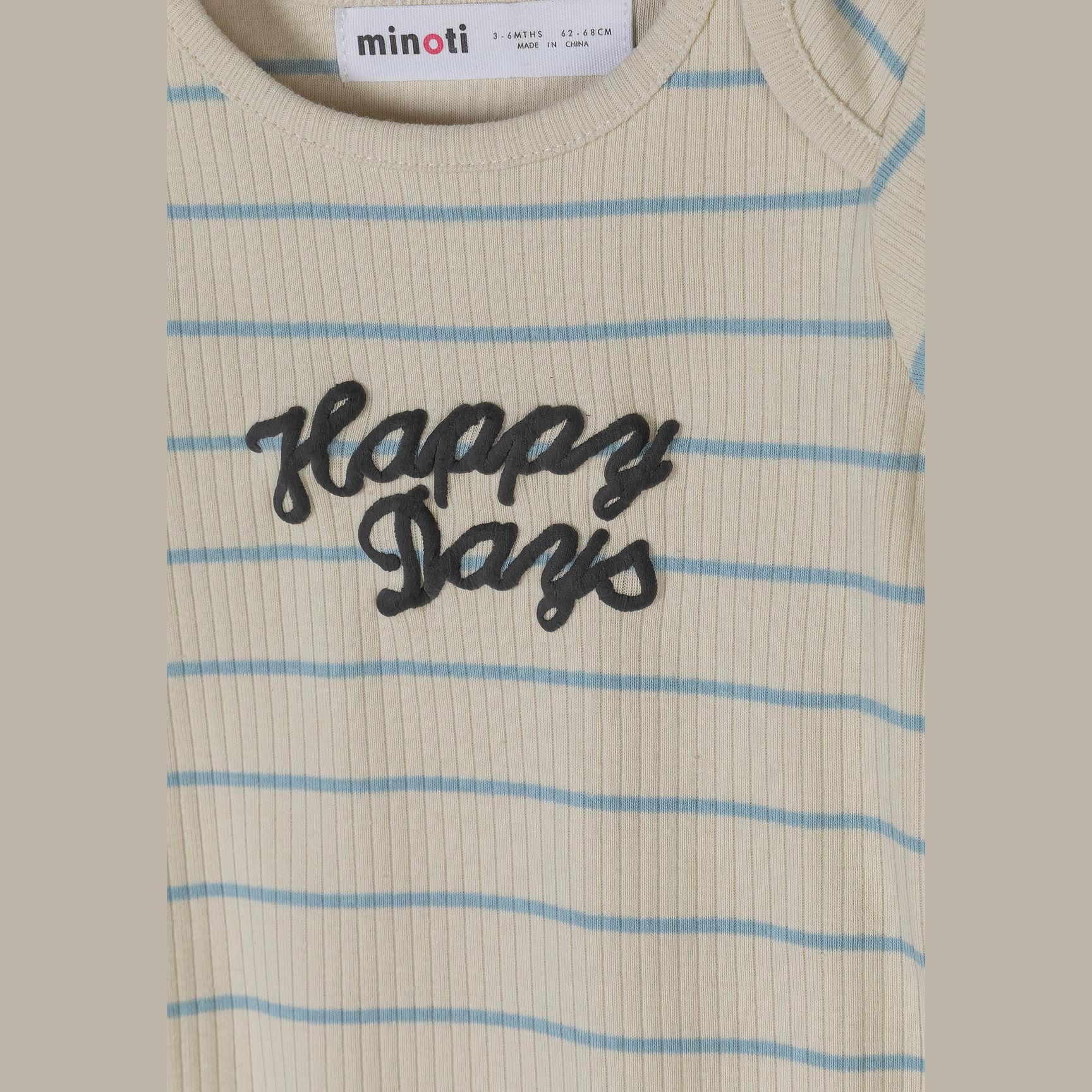 Detail view of Happy Days script lettering in dark grey on cream striped ribbed fabric with Minoti brand label visible at neckline