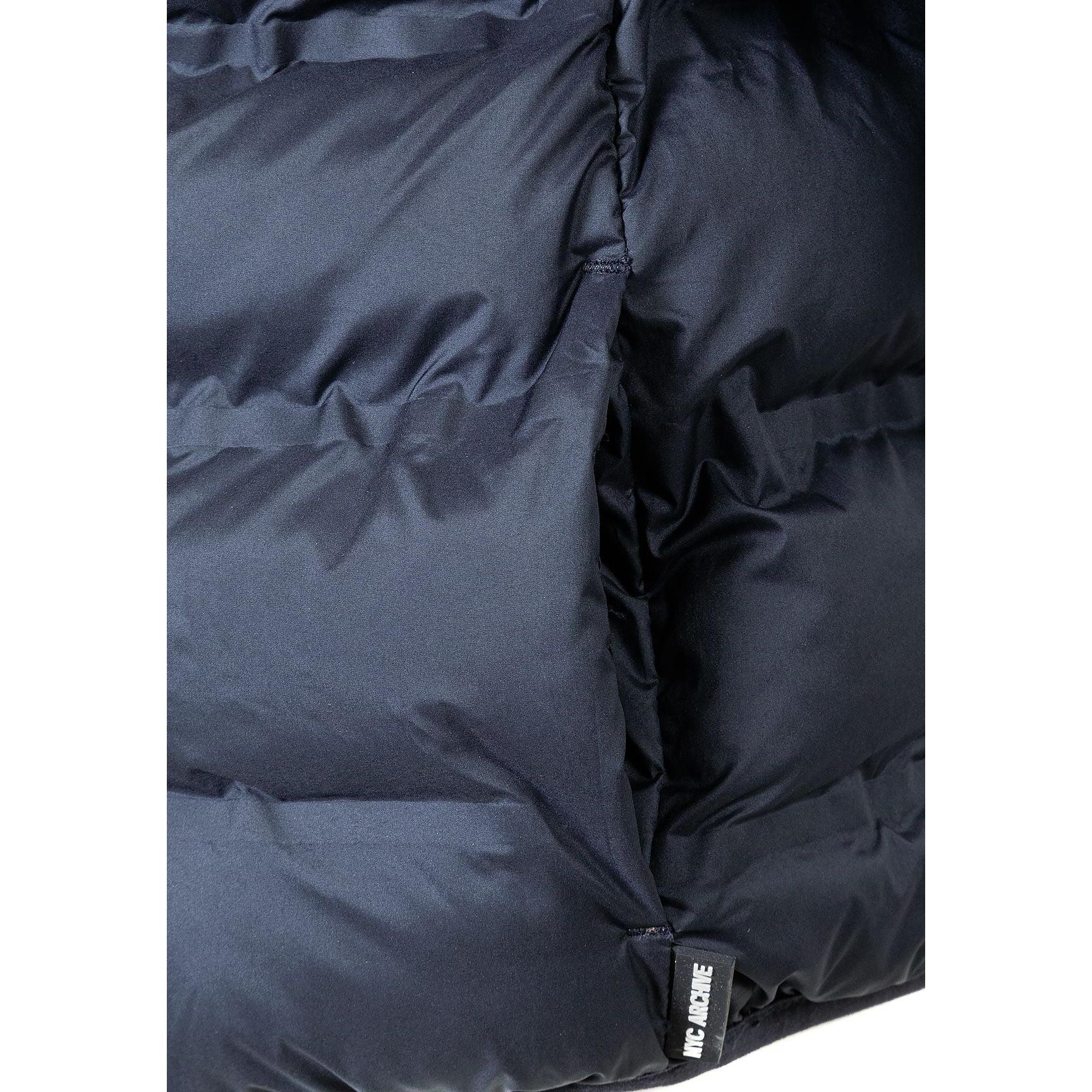 Close-up detail of navy quilted fabric texture showing stitching pattern and material finish