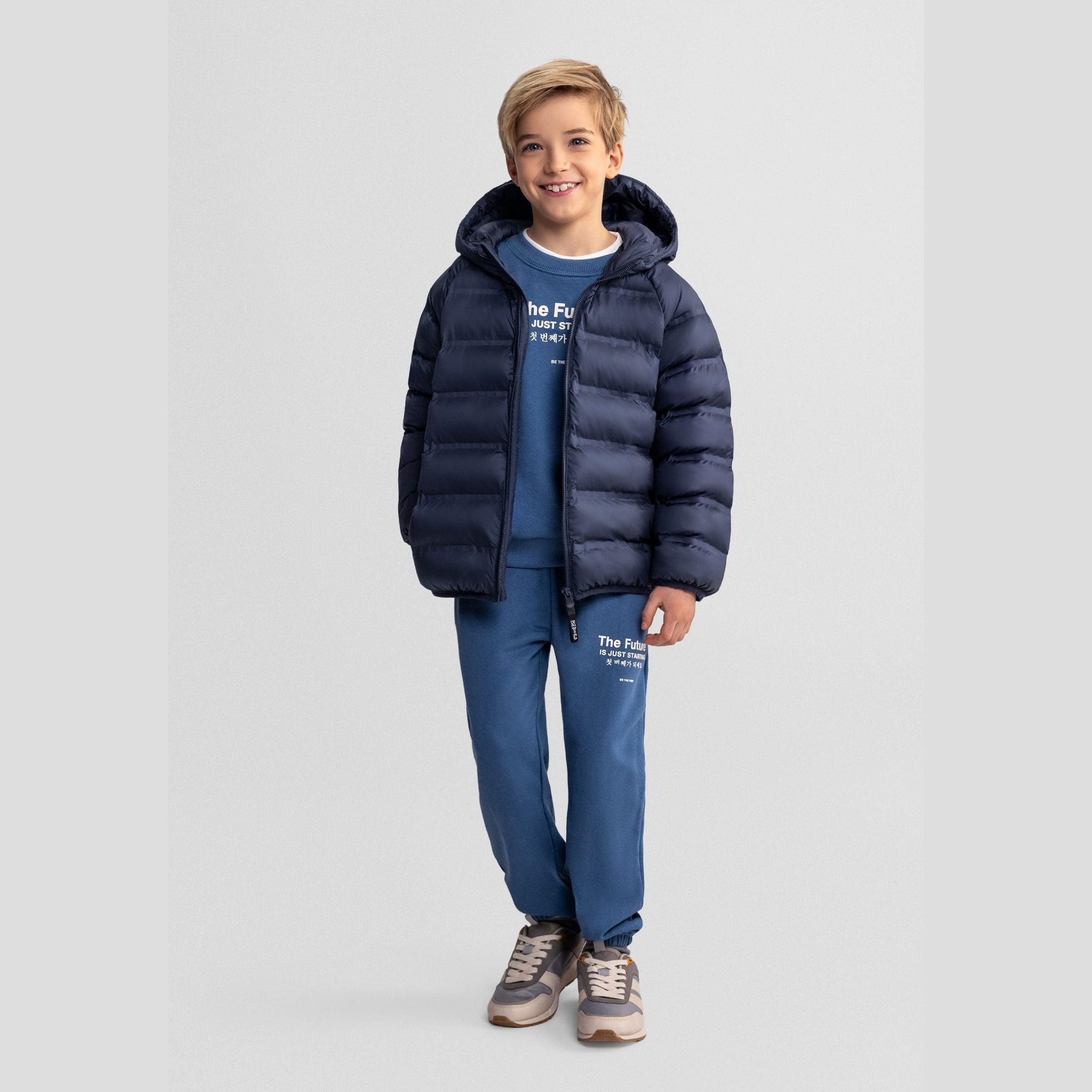 Navy blue quilted jacket laid flat showing full zip closure and hood detail on white background