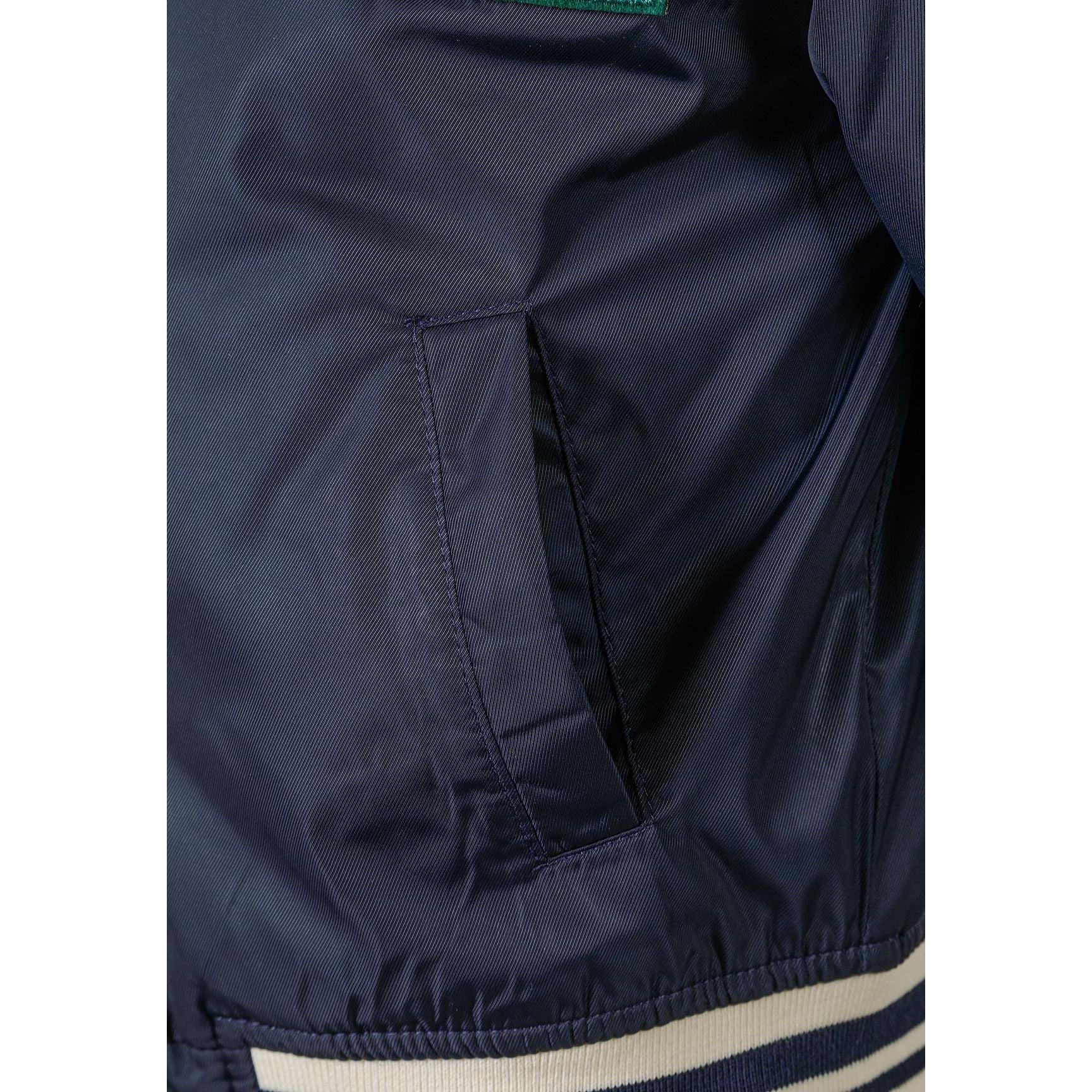 Close-up detail of navy bomber jacket showing inner pocket and quilted lining construction