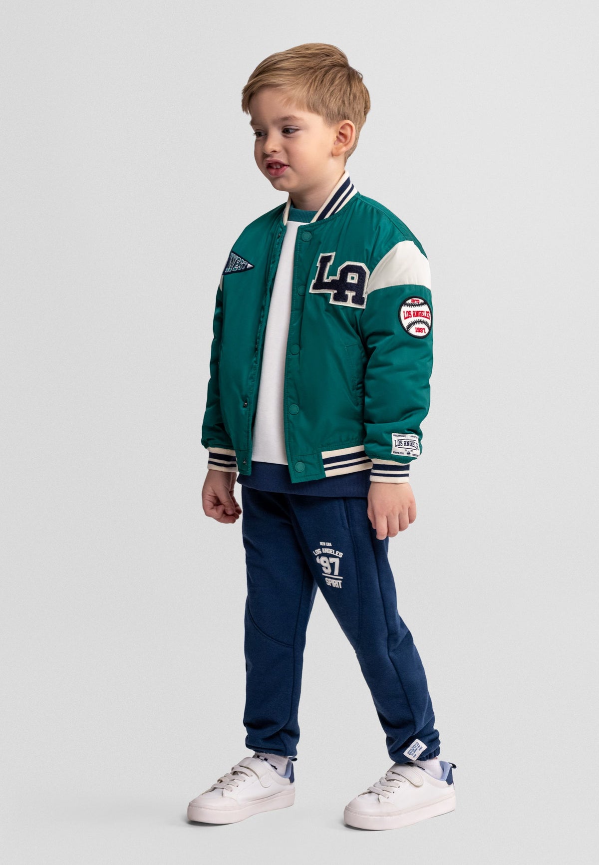 Boys' green varsity jacket, shown worn.