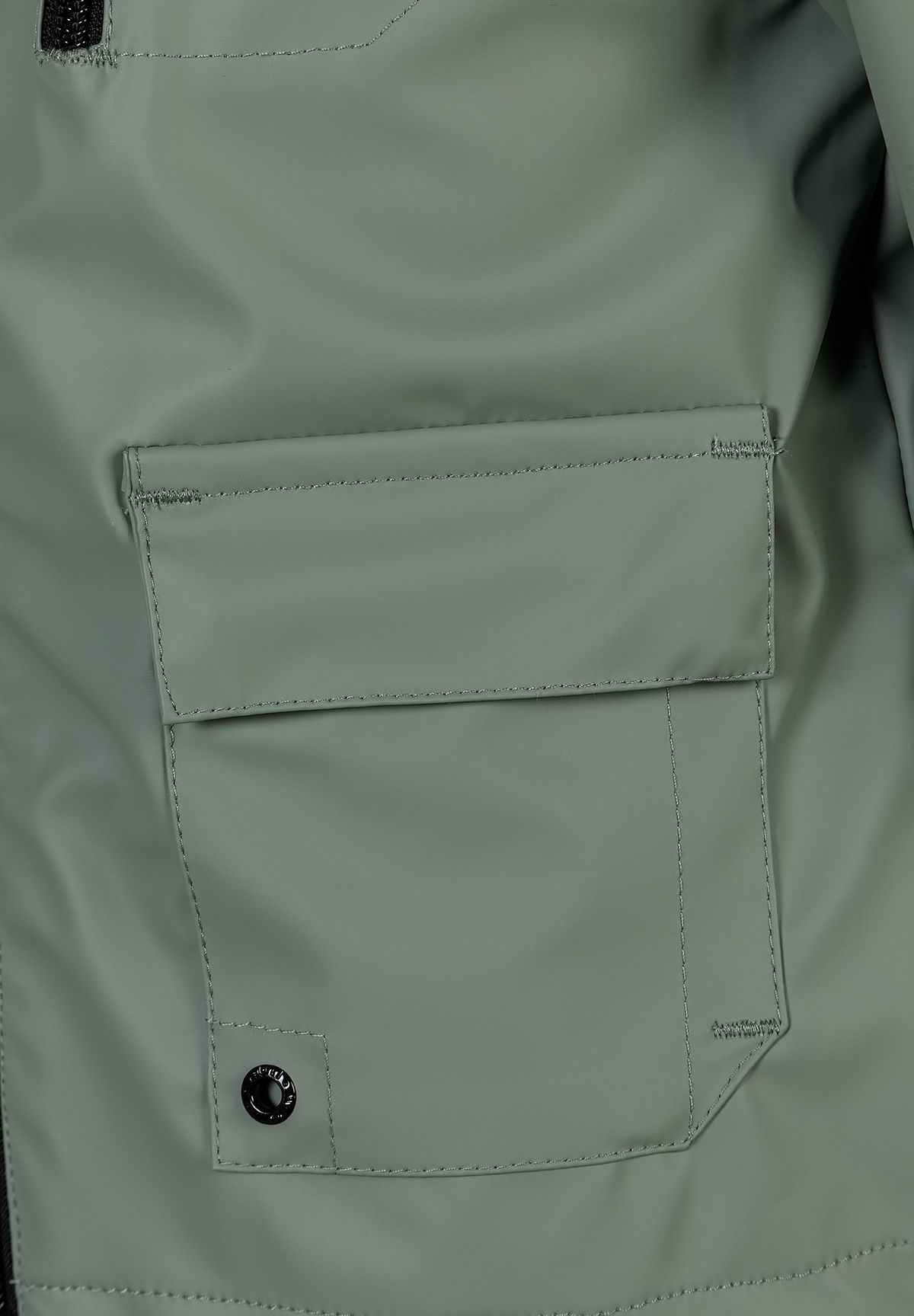 Close-up of sage green cargo-style jacket pocket with flap and black snap detail.