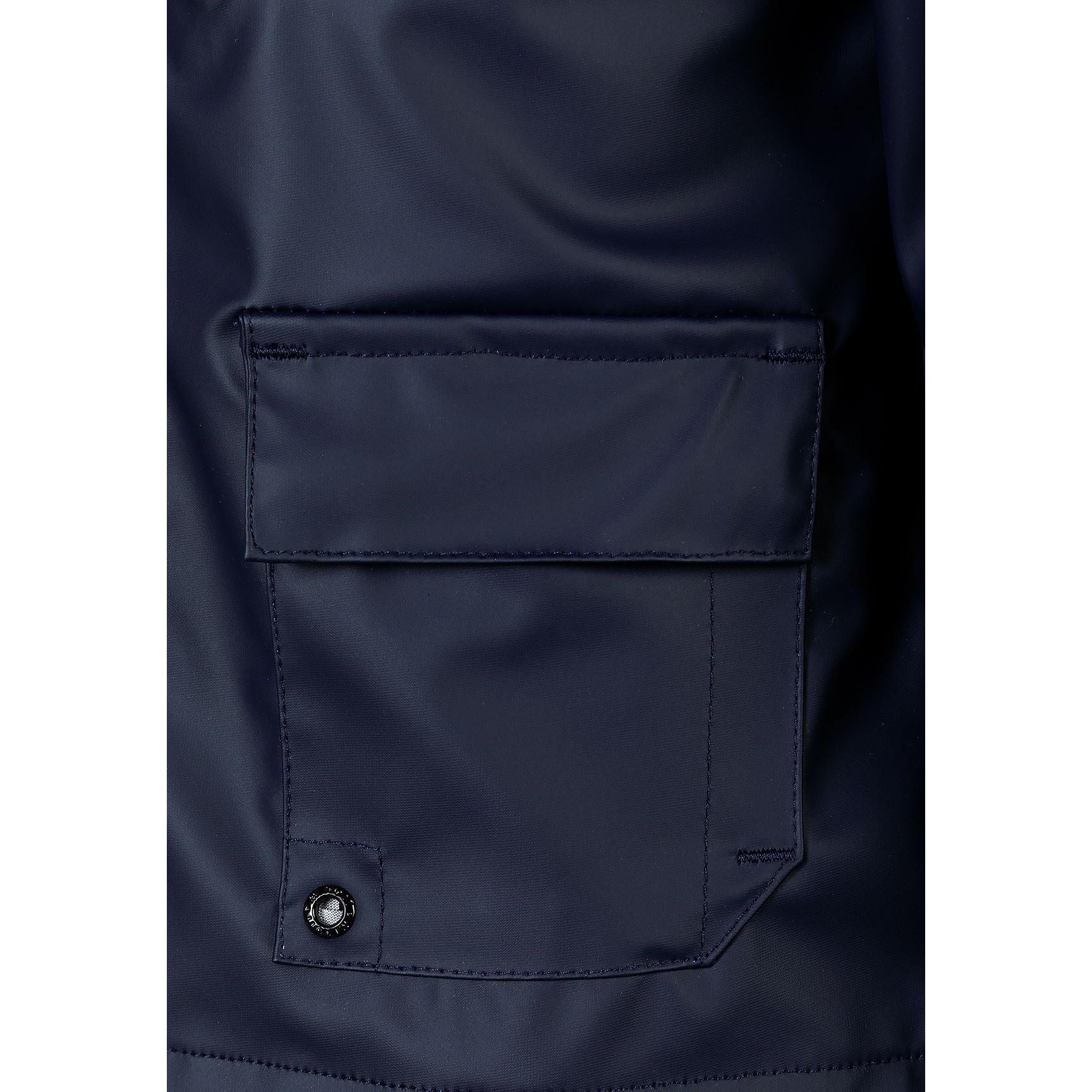 Close-up detail of navy parka jacket showing cargo pocket with flap closure and snap button on navy fabric
