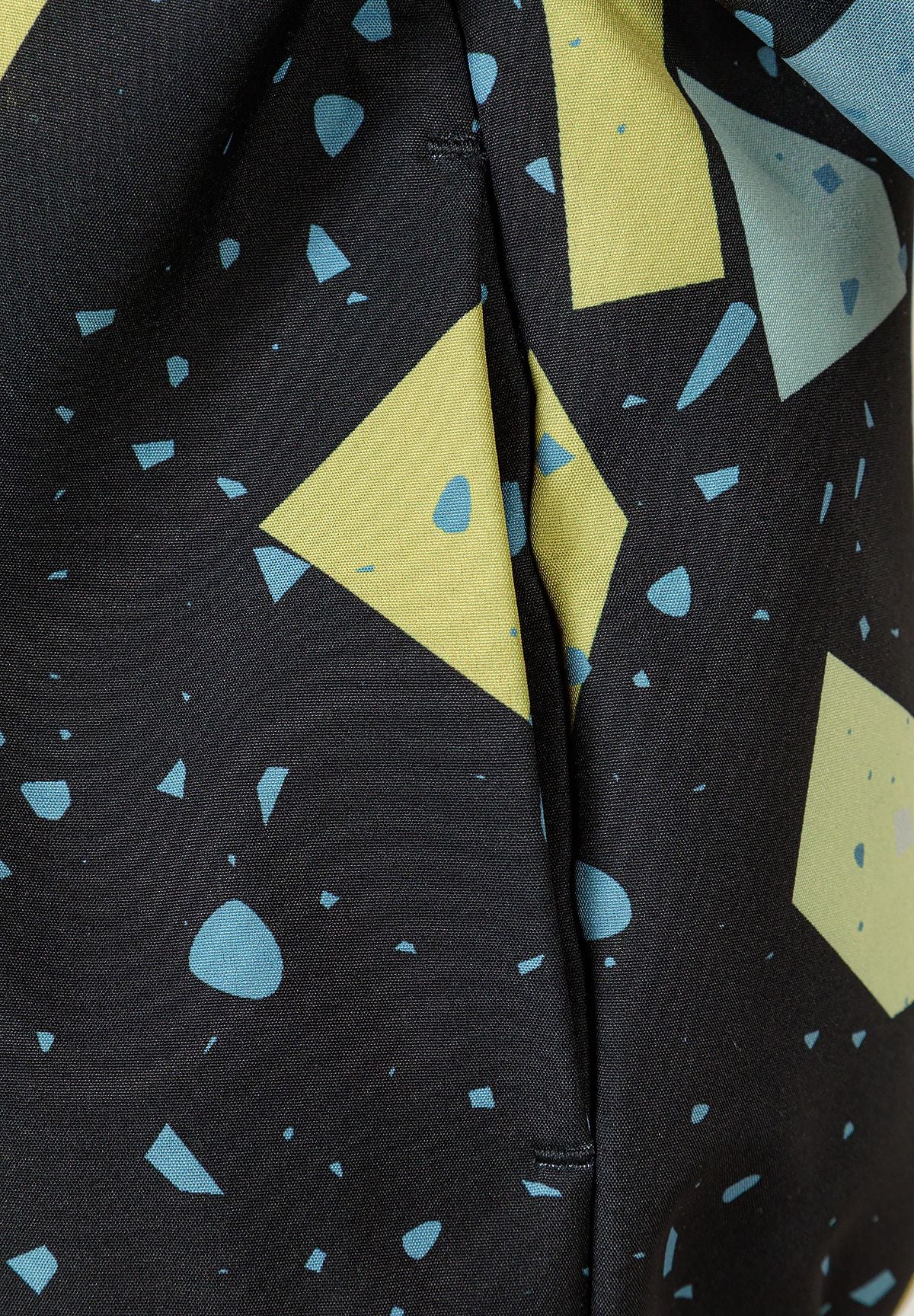 Close-up of side-seam pocket in black, blue and lime geometric jacket.