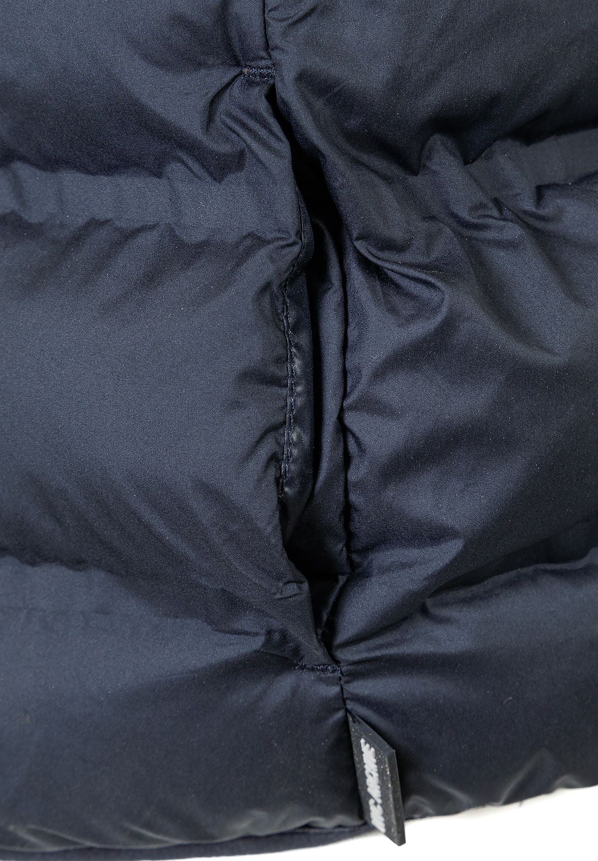 Detail of navy blue lightweight gilet with padding and side pocket.