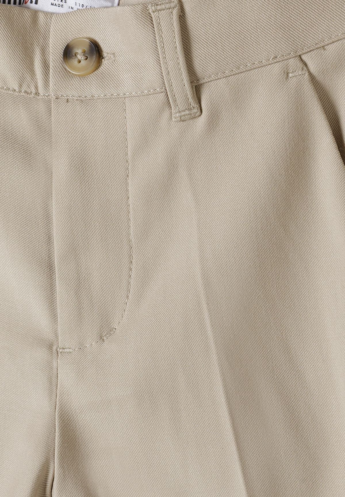 Detail of boys formal trousers in stone color with adjustable waistband and side pocket.