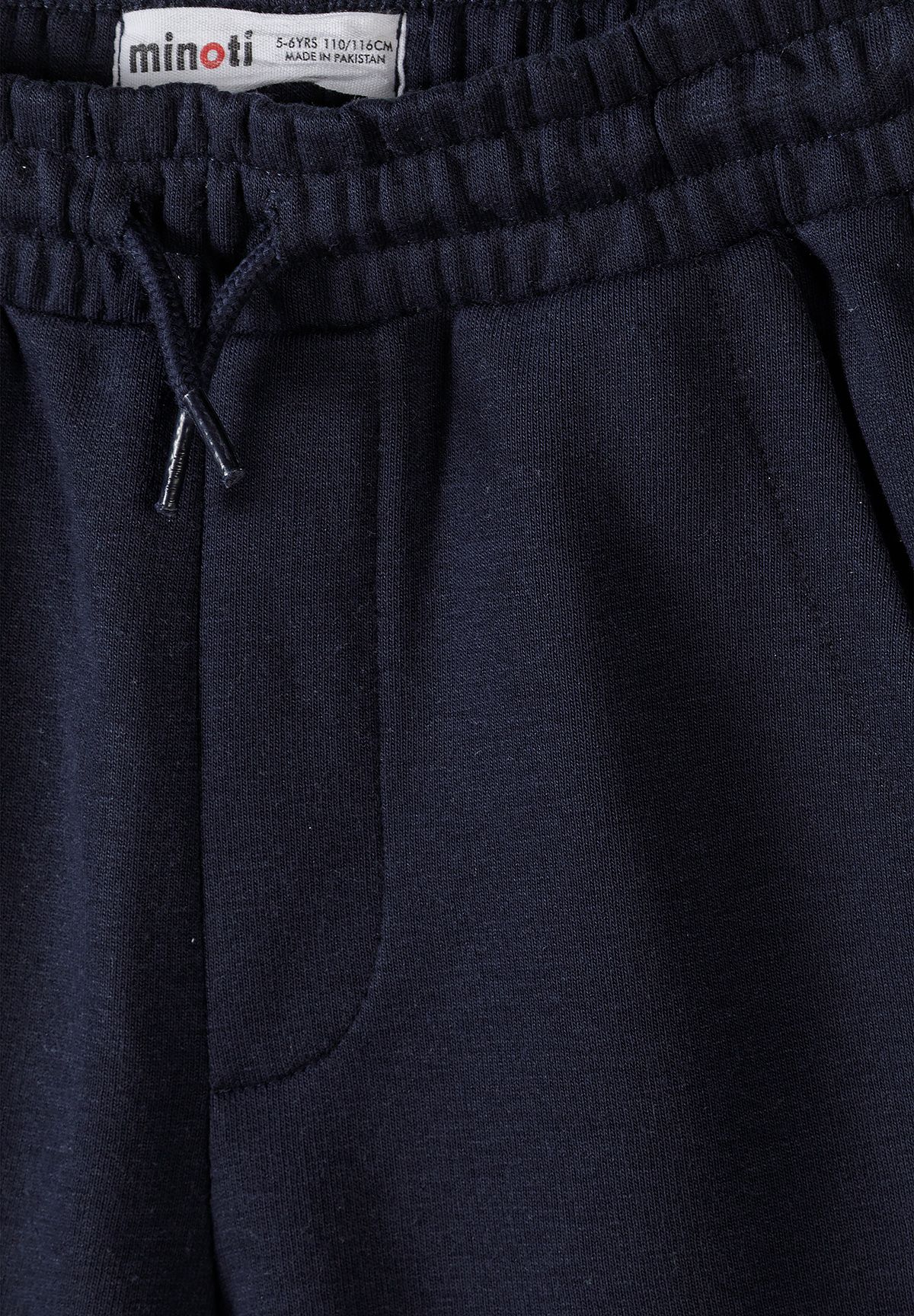 Close-up of navy jogger shorts' gathered waist, drawcord and slanted side pocket.