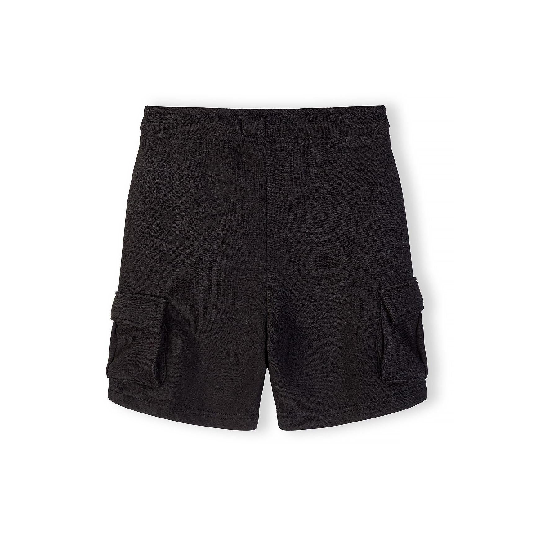 Detail shot of black cargo shorts waistband area showing drawstring ties and fabric texture with small label visible