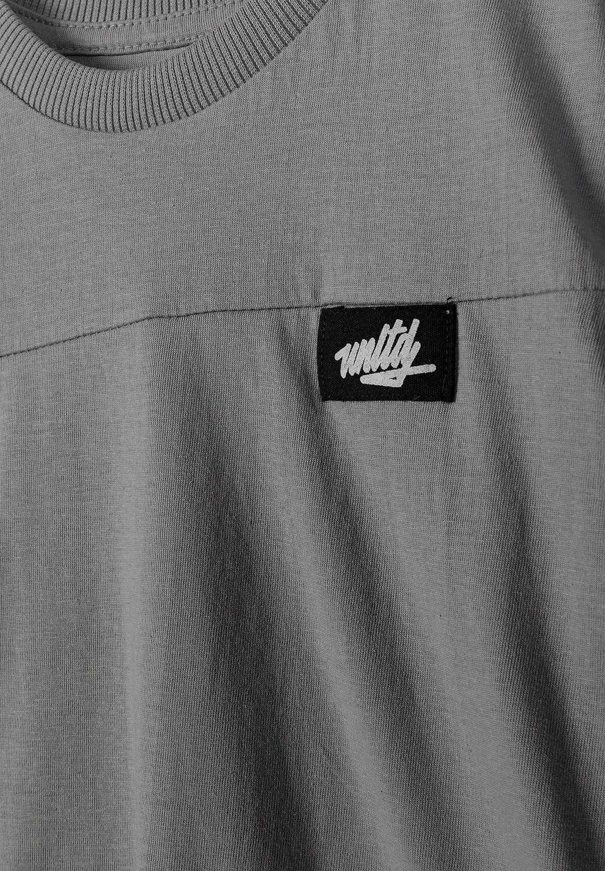 Detail of a grey short-sleeved T-shirt with a logo tag.