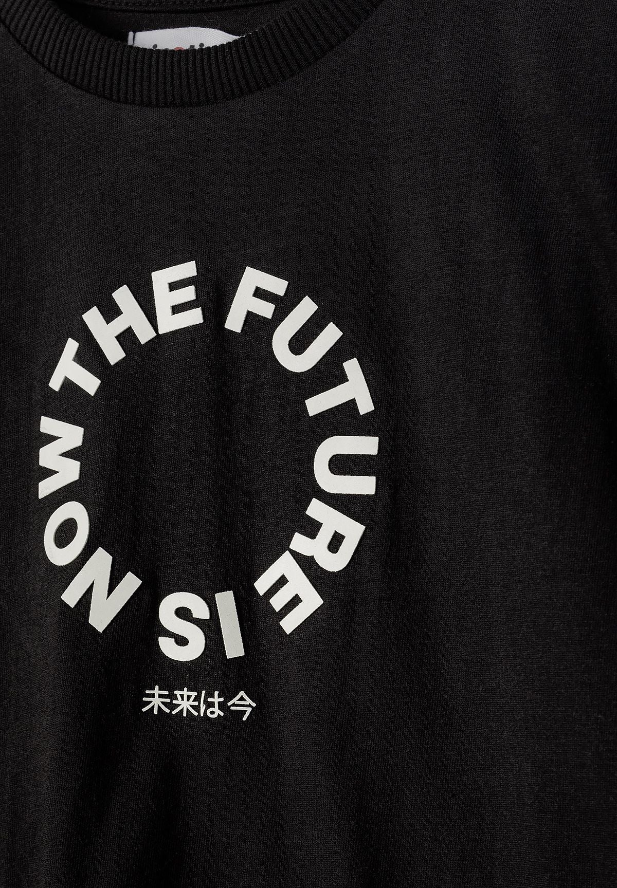 Close-up of a black boys' t-shirt with a circular white graphic print.