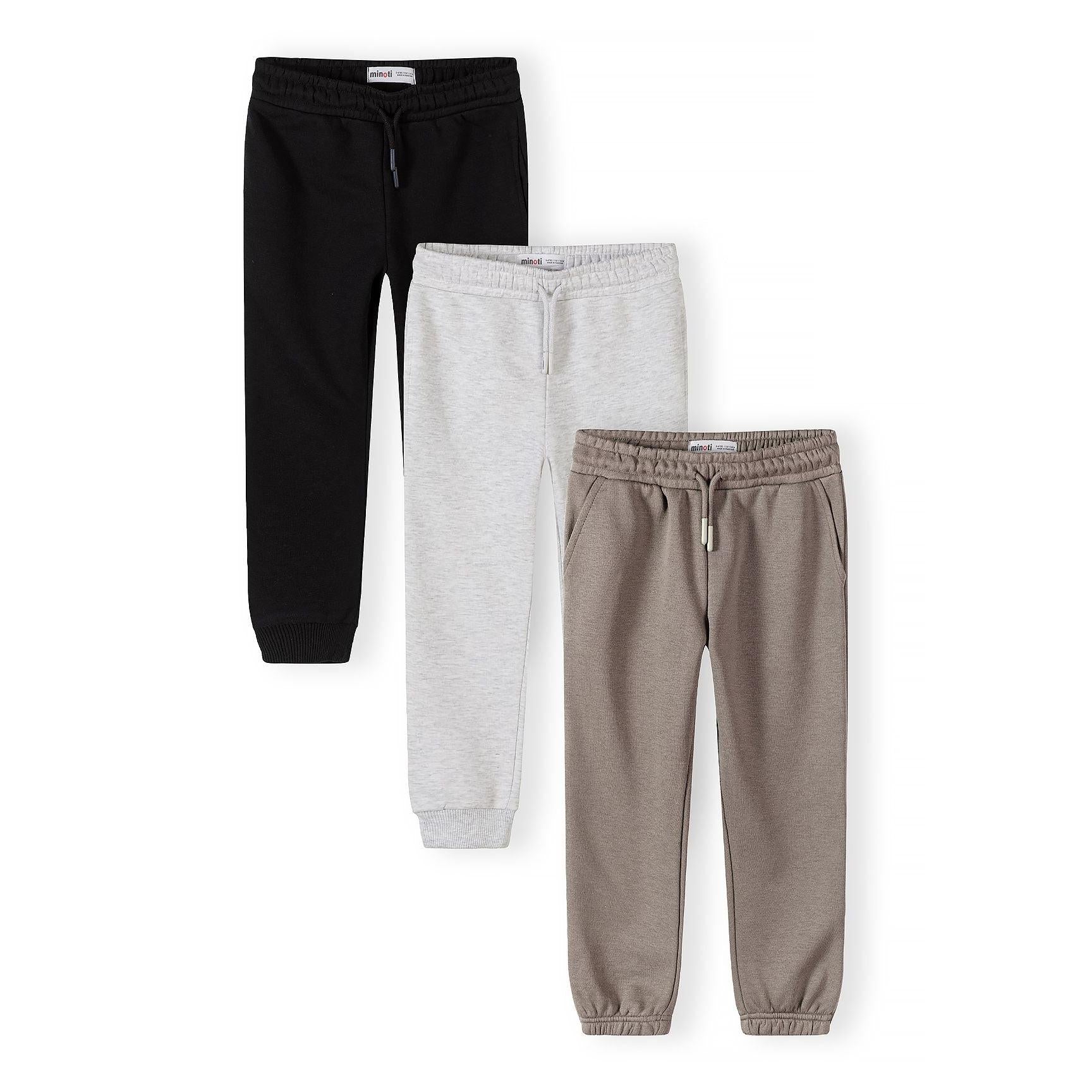 Three joggers laid flat showing black, grey and beige colors with elastic waistbands and cuffs against white background