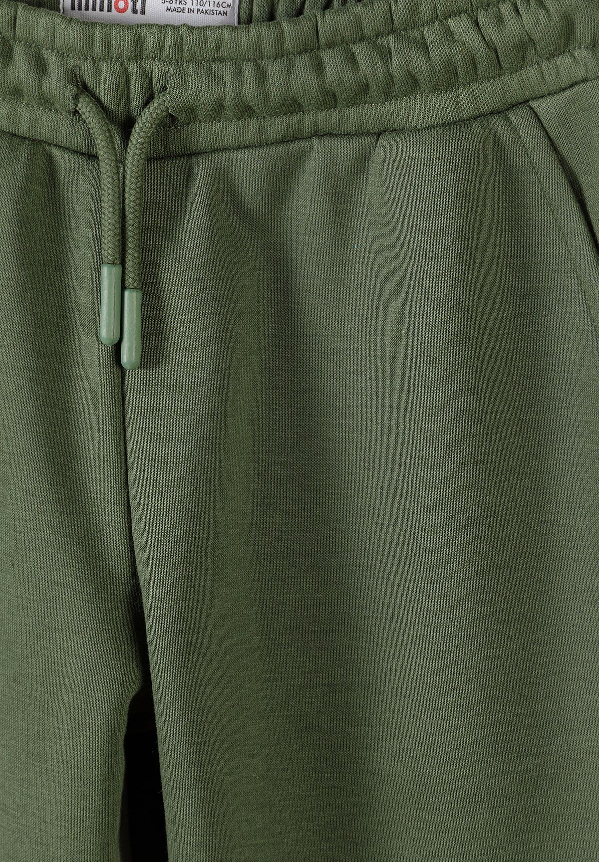 Close-up of olive joggers' gathered waist, green tipped drawcord and slanted side pocket.