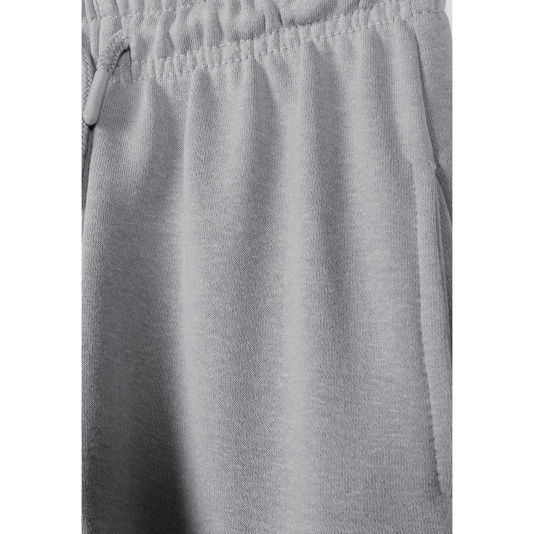 Close-up detail of grey jogger fabric texture and elasticated waistband with drawstring ties