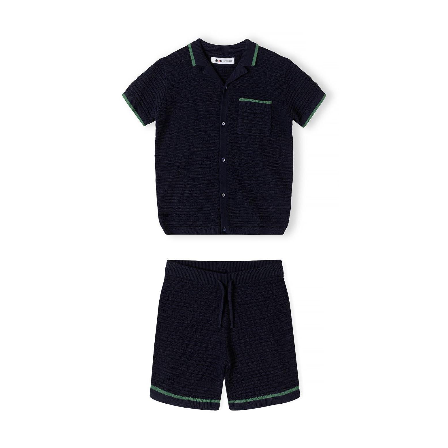 Back view of navy blue knitted polo shirt showing textured waffle-knit fabric and green contrast trim at neckline and sleeves