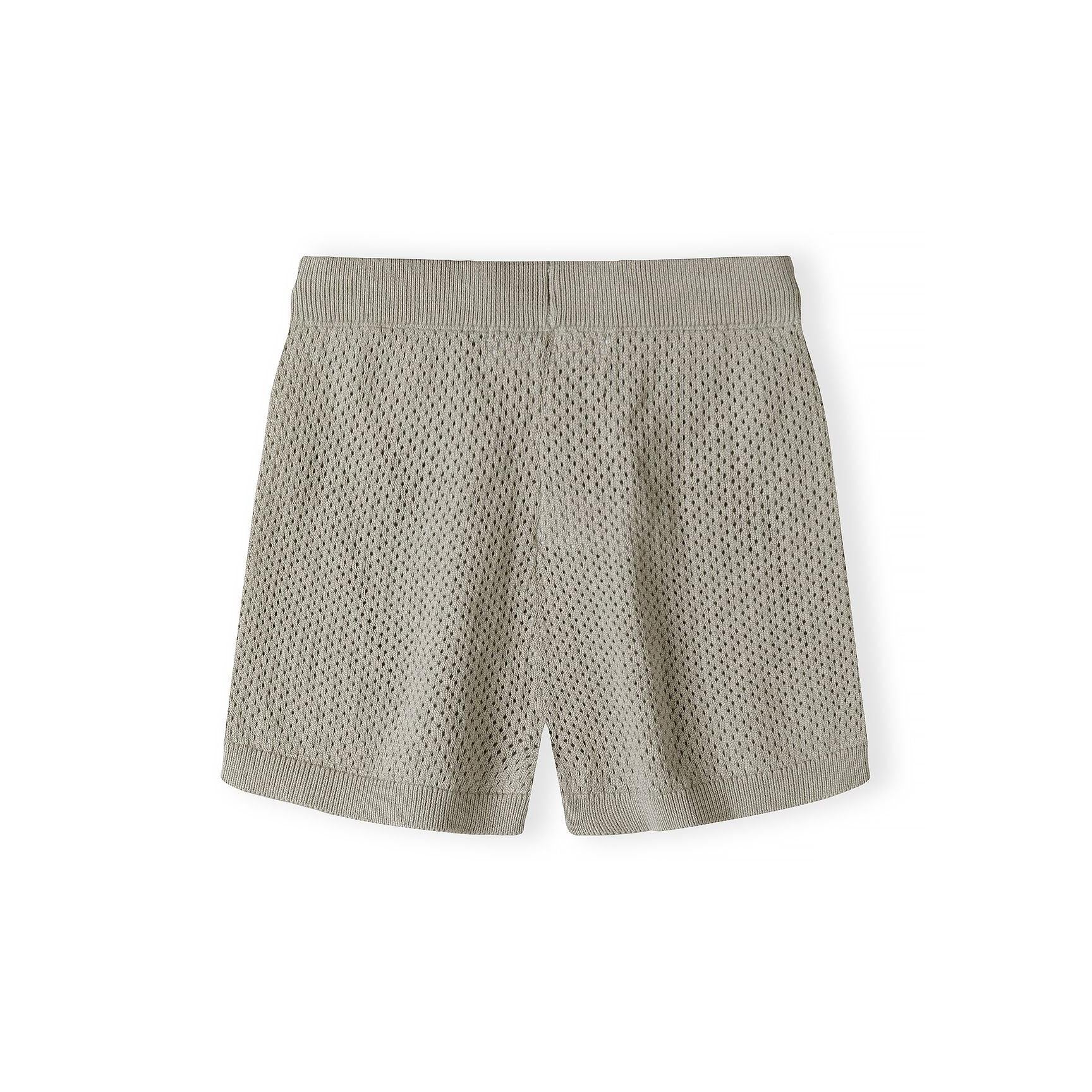 Close-up detail of khaki knitted shorts waistband showing textured mesh pattern fabric and drawstring tie on white background