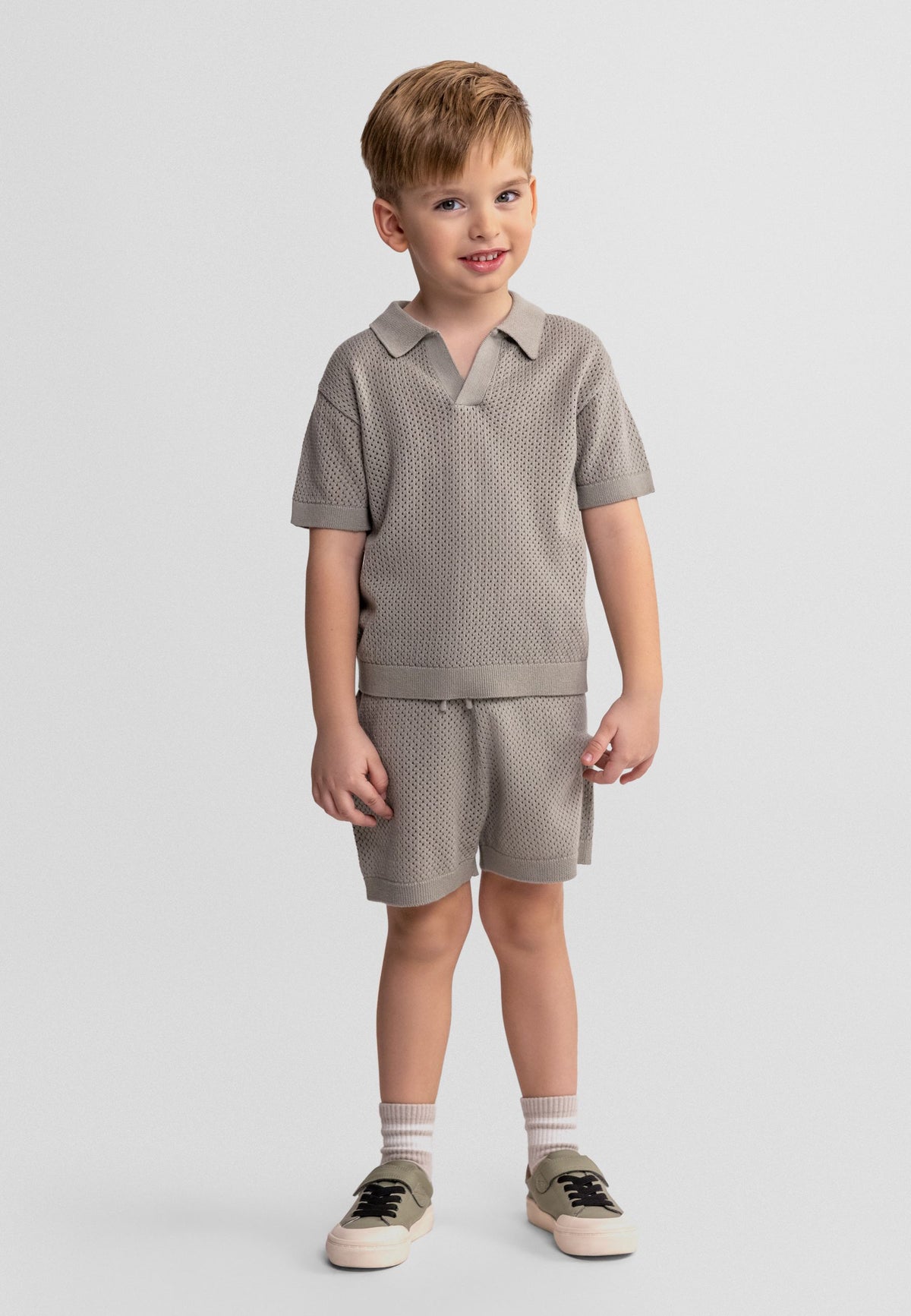 Grey green knitted polo and shorts set, model front.