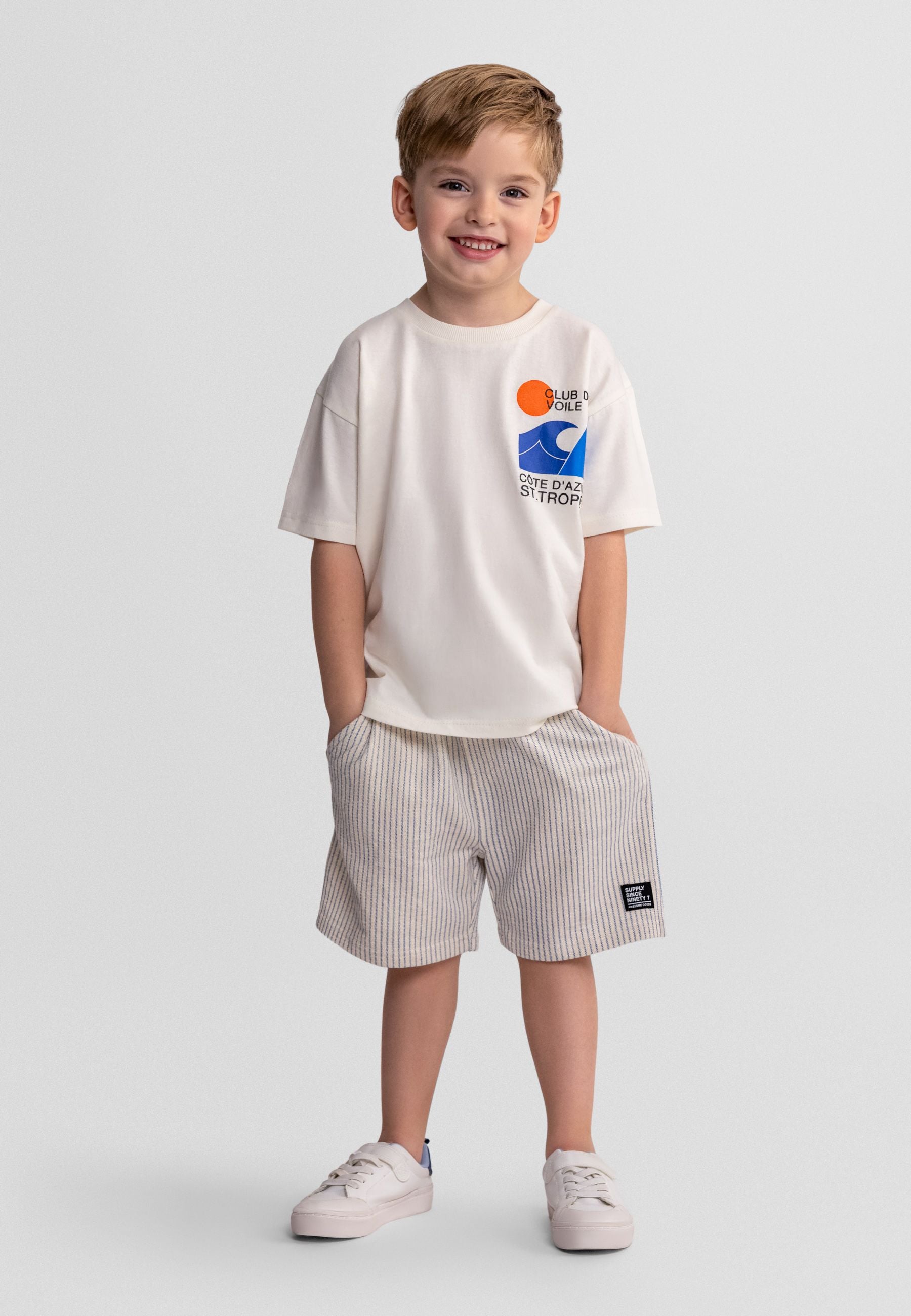 Boys' offwhite short sleeve shirt with striped shorts, featuring a logo print and elastic waistband.