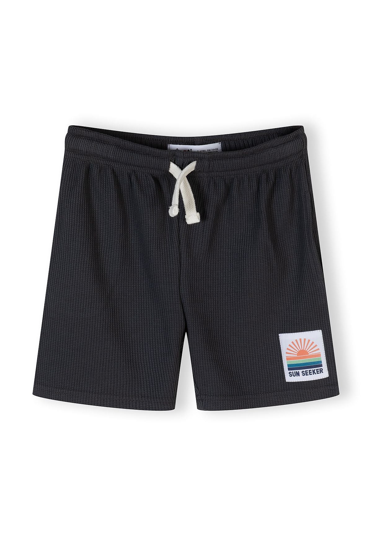Close-up of waffle-textured shorts in gunmetal with elasticated waistband and logo patch.