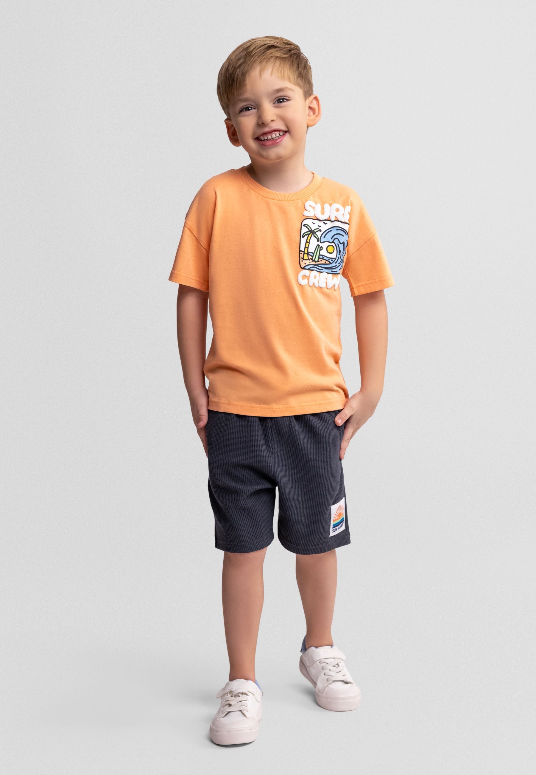 Boys' apricot t-shirt with graphic and gunmetal waffle shorts, front view.