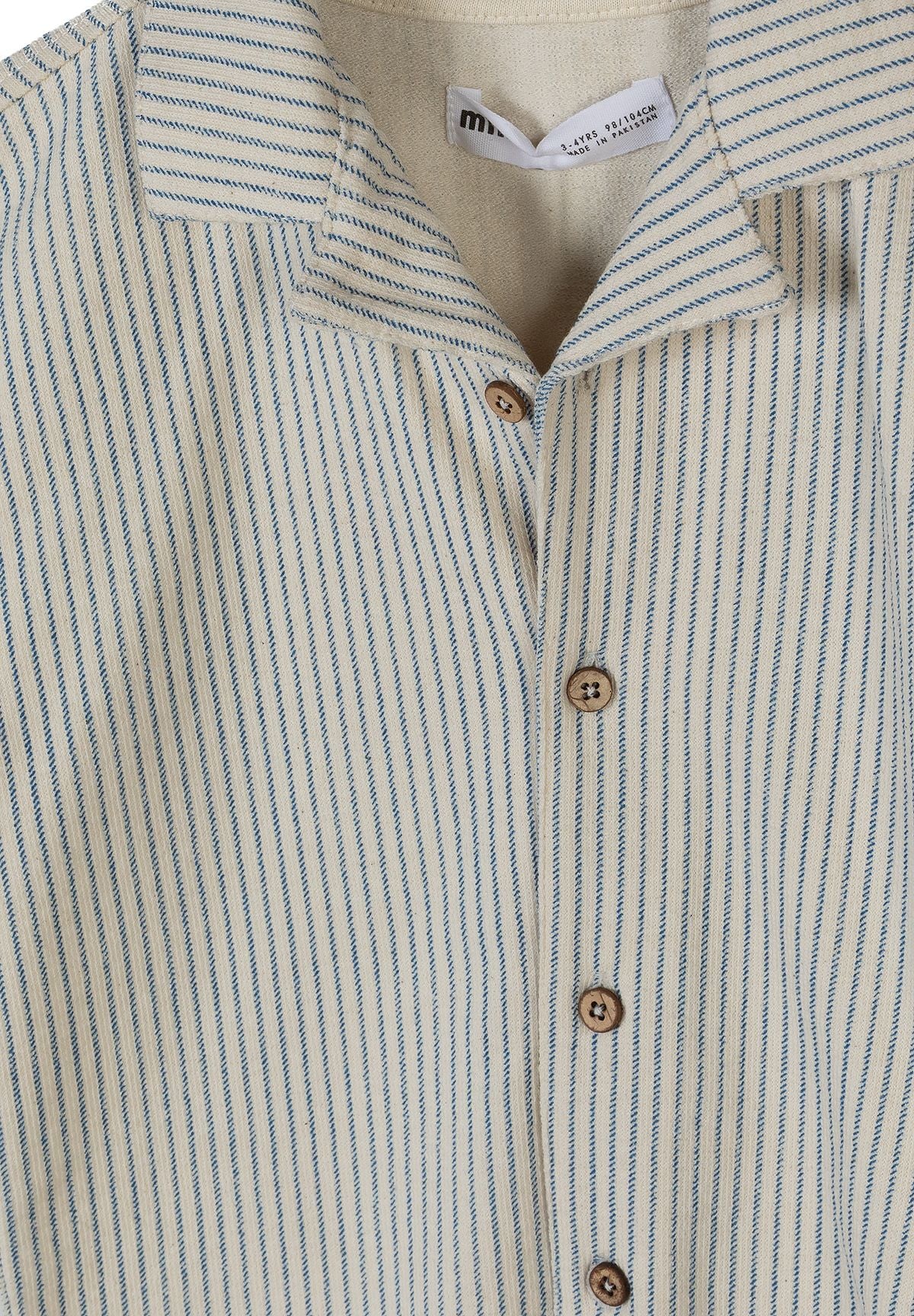 Detail of a boys' offwhite striped shirt with front buttons and classic collar.