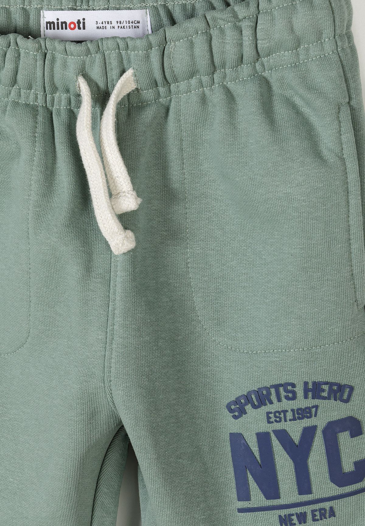 Detail of teal joggers with elasticated waistband and logo print.