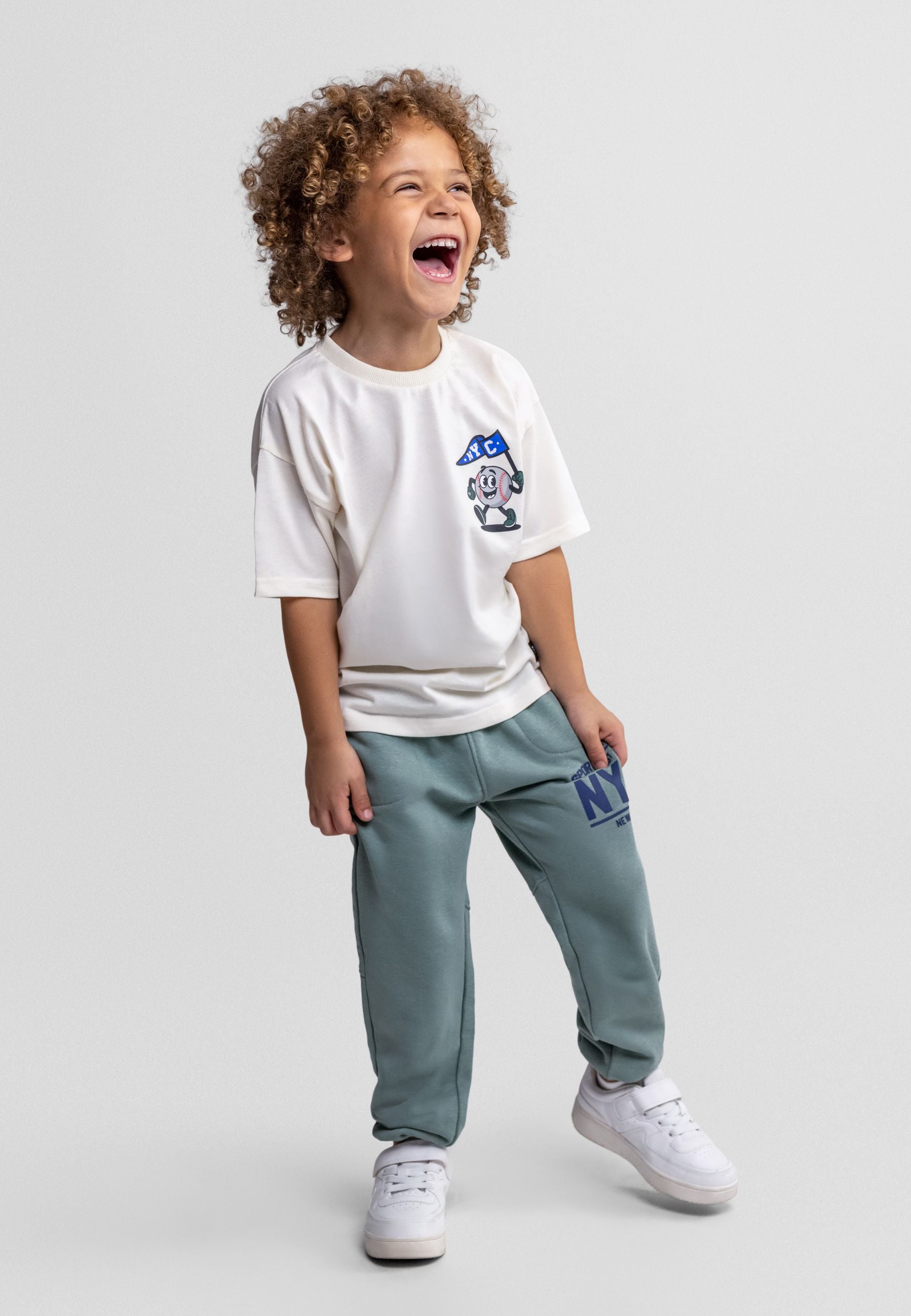 Boys' off-white graphic t-shirt with teal joggers, front view, featuring crew neck and elasticated waistband.