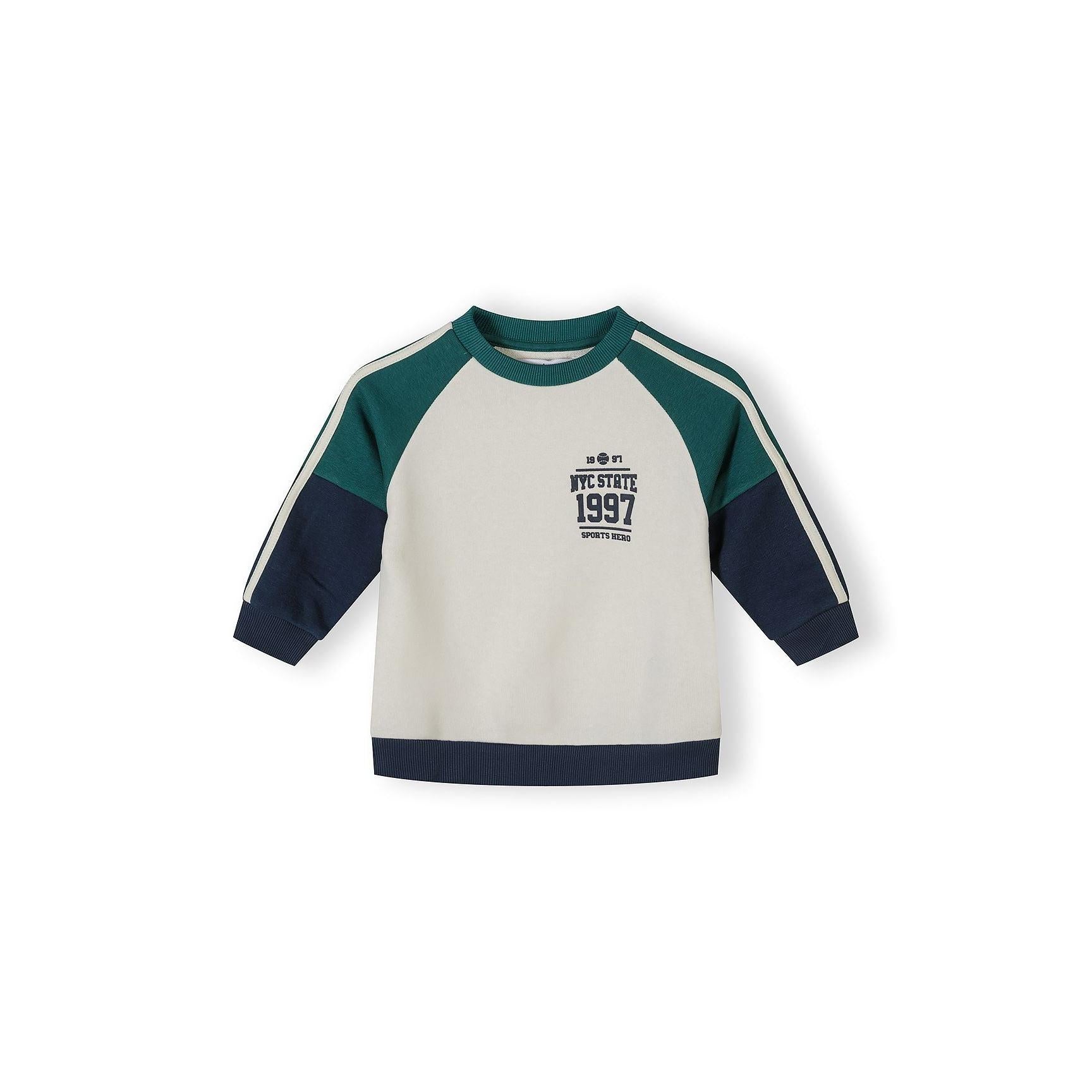 Close-up detail of sweatshirt chest area showing NYC State 1997 Sports Hero print in navy lettering on cream fabric with green neckline