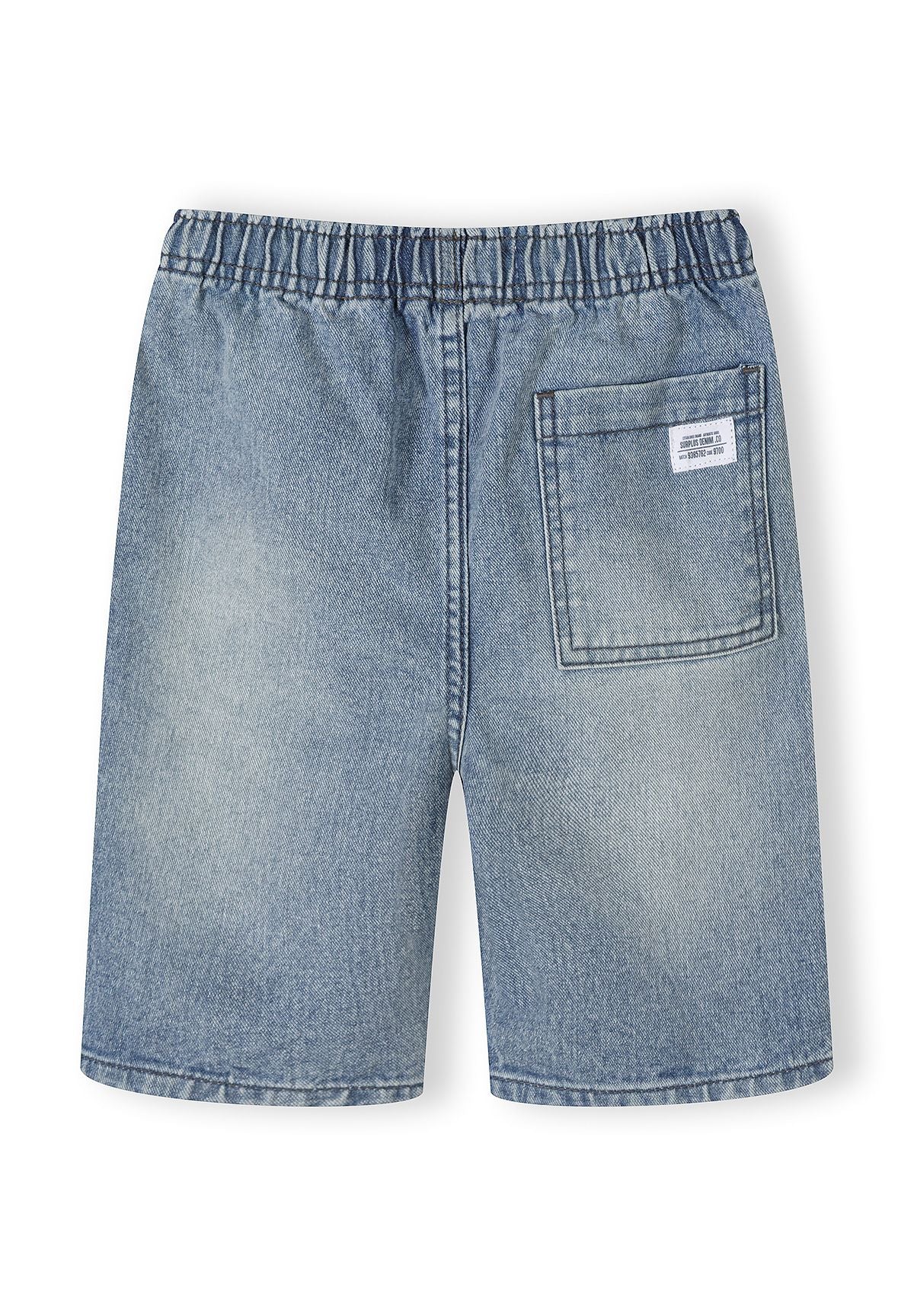 Close-up detail of denim shorts waistband showing elastic construction, cream-colored drawstring ties, and denim texture