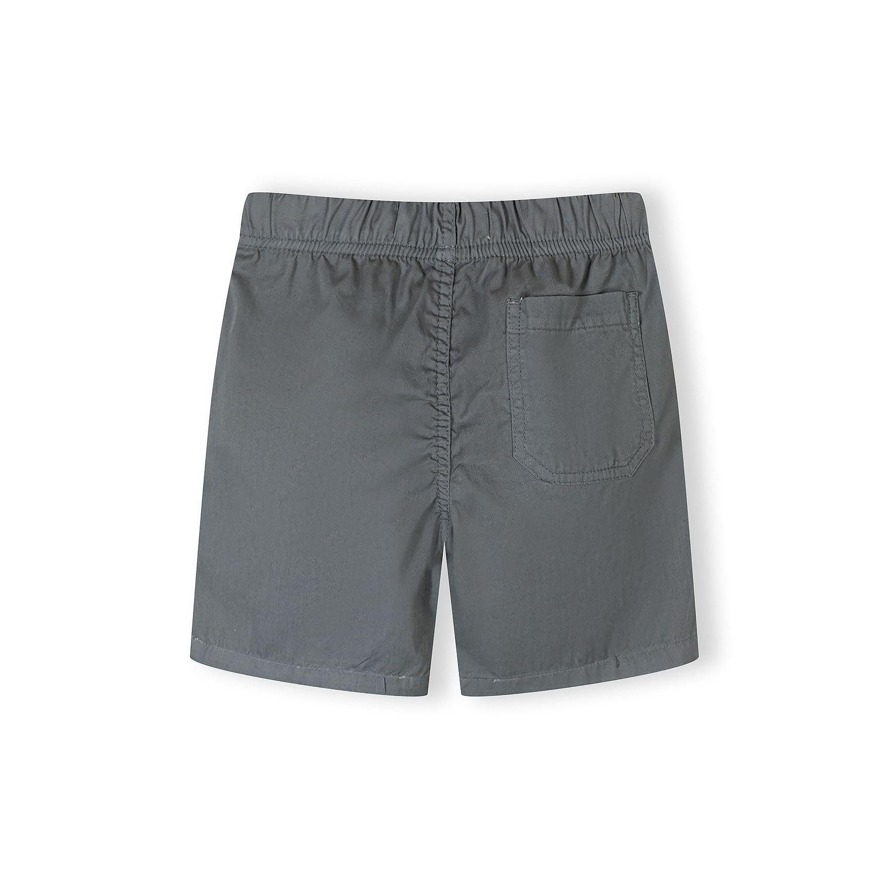 Close-up detail of grey shorts waistband showing Minoti label, elasticated gathering and white drawstring with black pattern detail