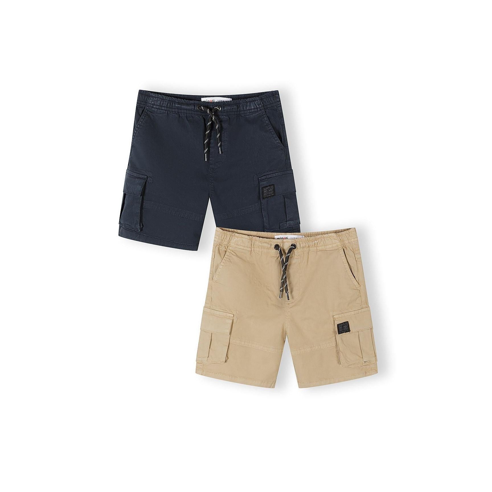 Two cargo shorts laid flat on white background, one navy blue and one beige, both featuring drawstring waists and cargo pockets