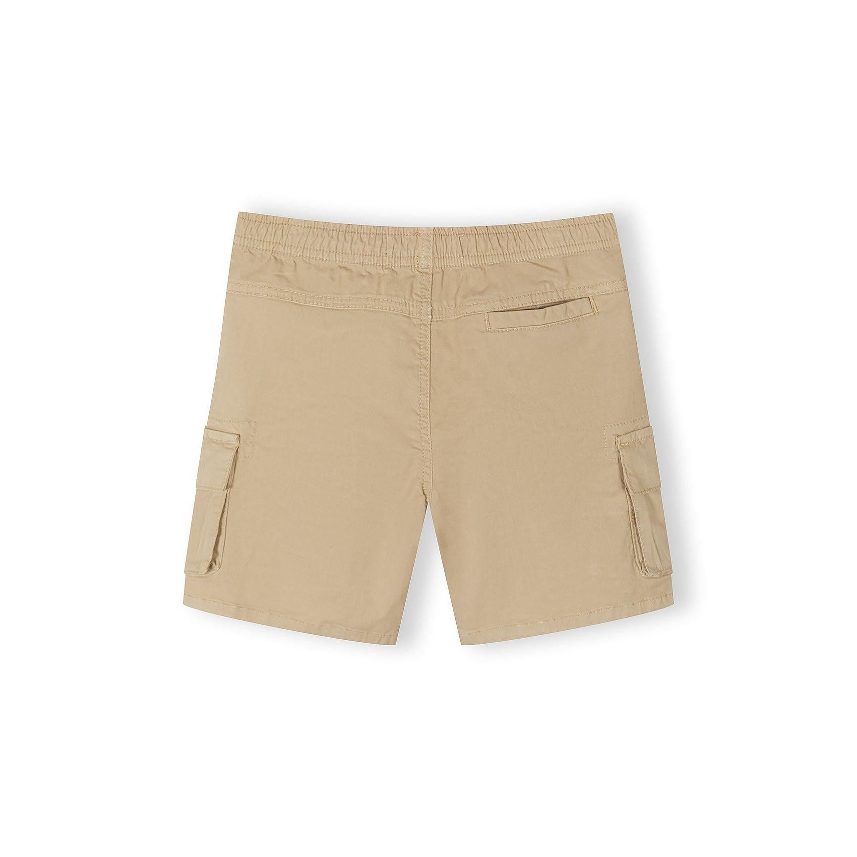 Close-up detail of beige cargo shorts showing drawstring waist with black and white striped cord and cargo pocket with dark label