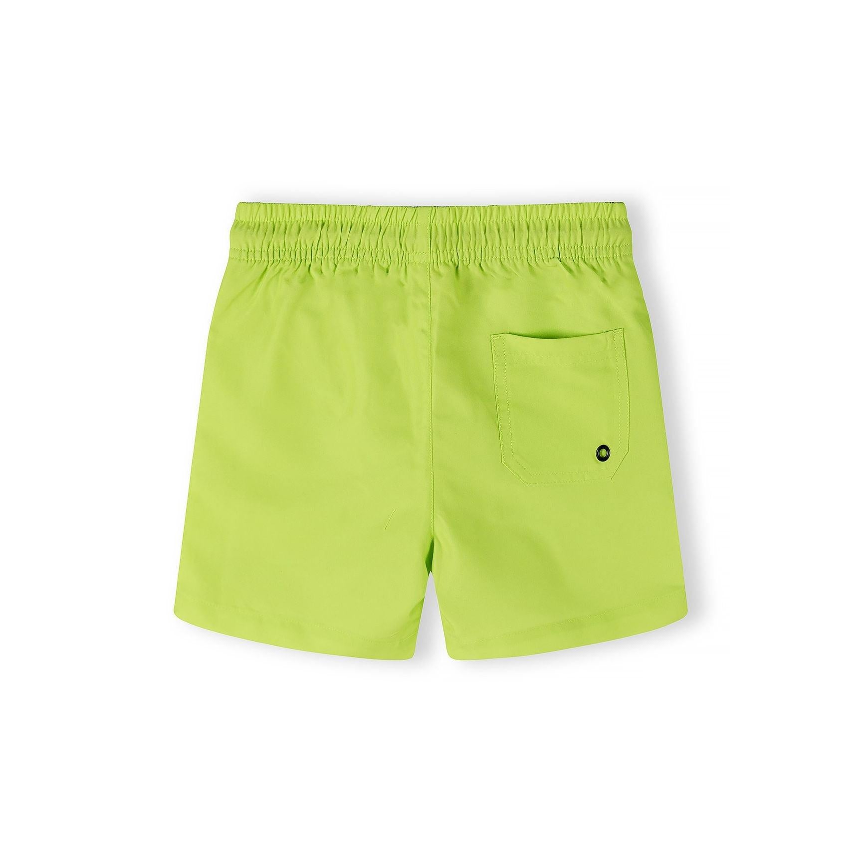 Close-up detail of lime swim shorts showing elastic waistband with blue trim, black drawstring with eyelets and embroidered blue logo